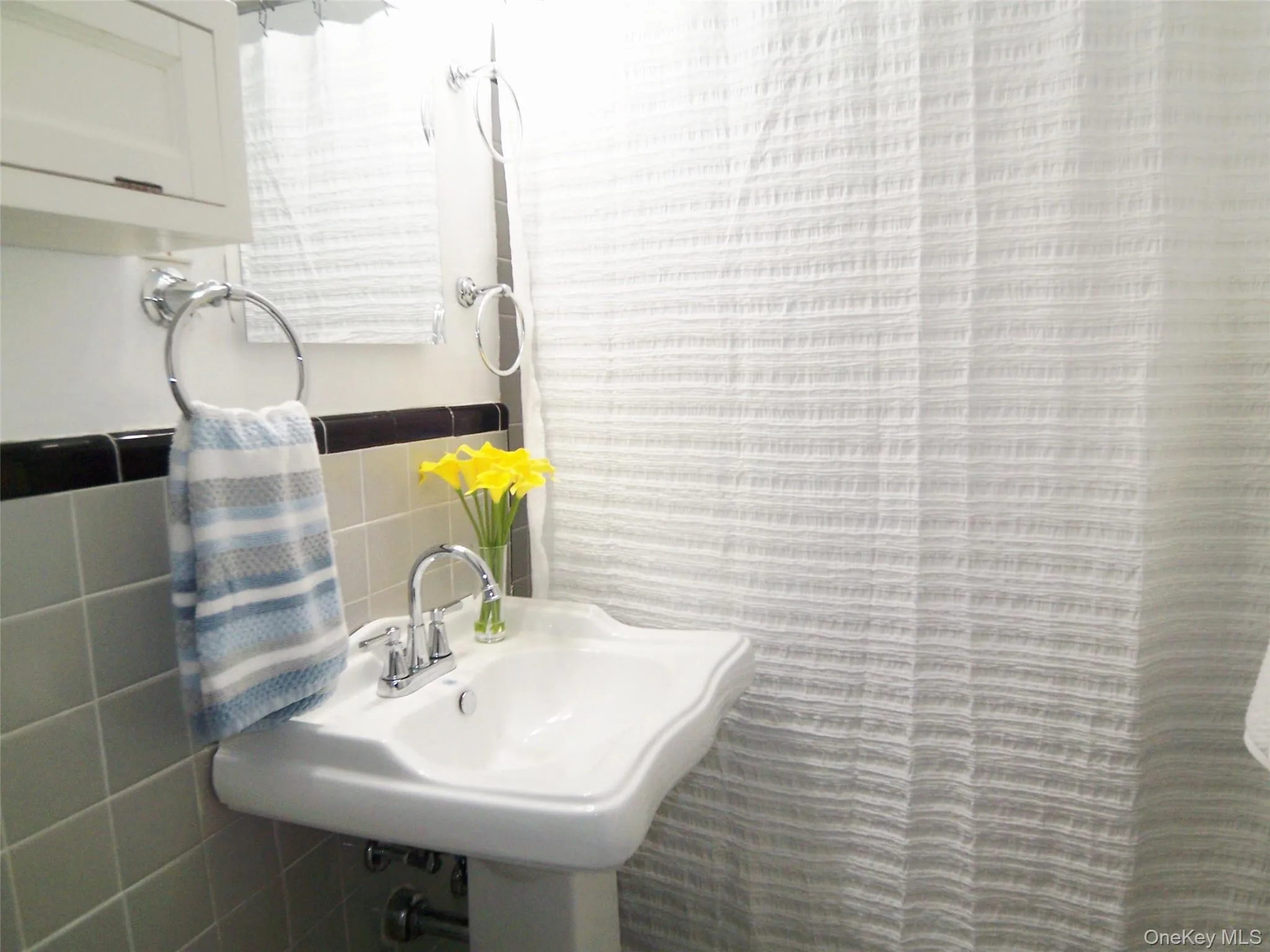 Bathroom with tile walls and a sink Bathroom with tile walls and a sink