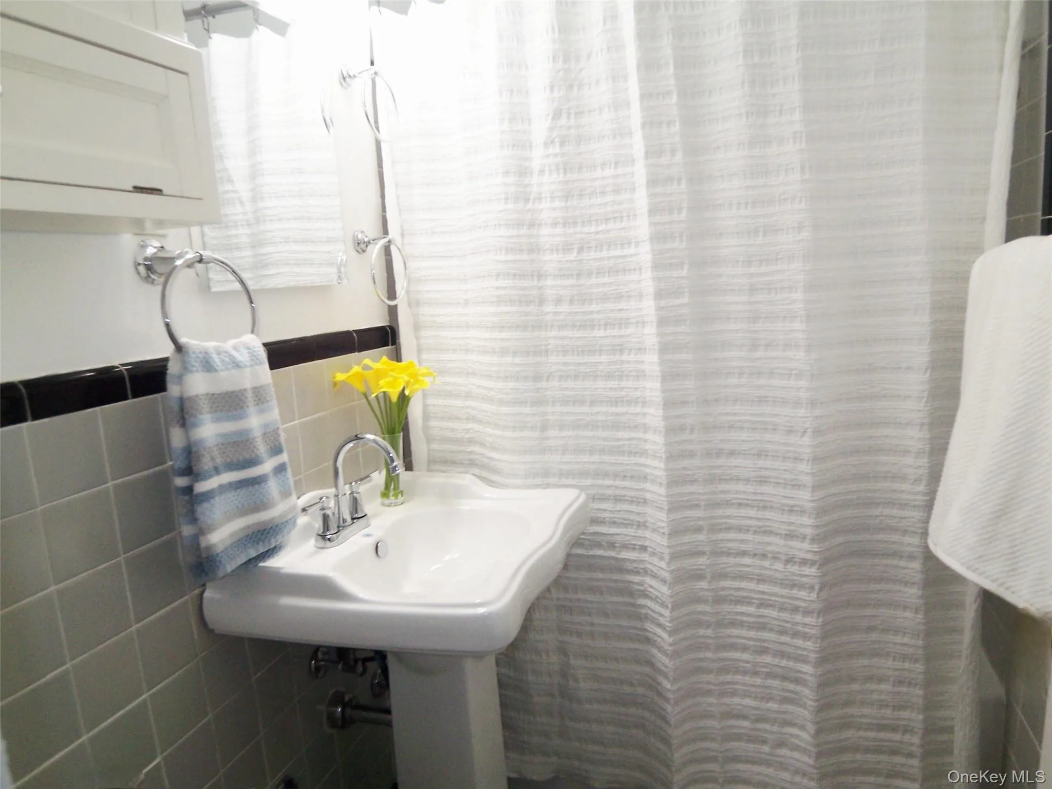 Full bathroom with tile walls and a shower with curtain Full bathroom with tile walls and a shower with curtain