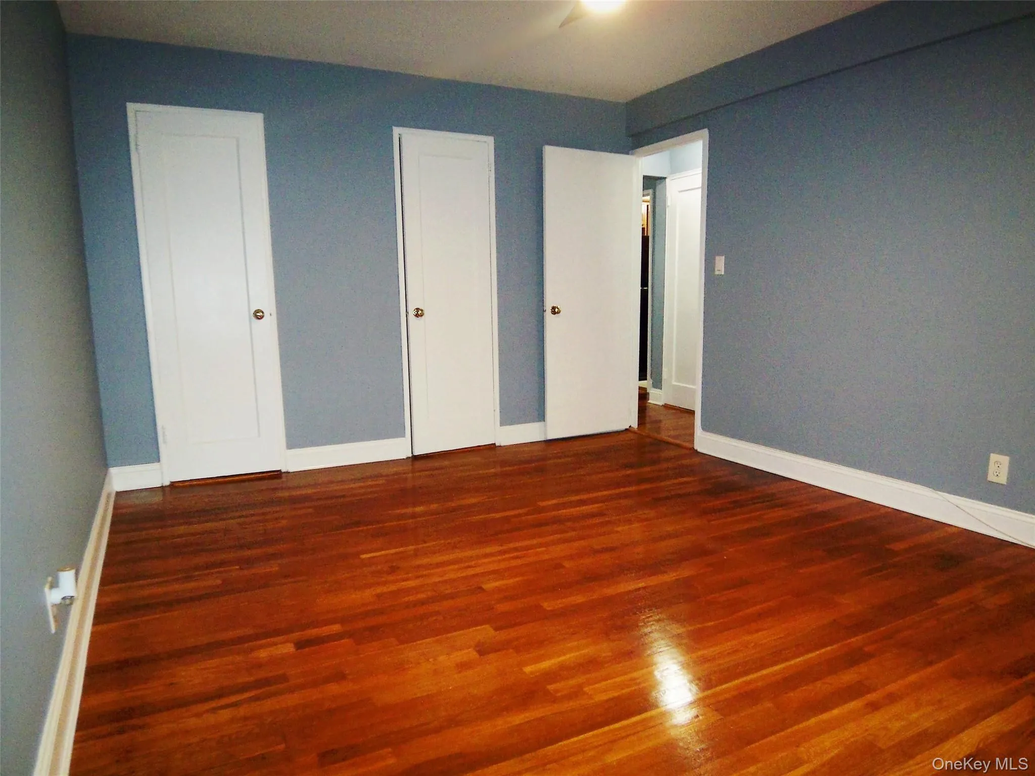Unfurnished bedroom featuring wood finished floors and baseboards Unfurnished bedroom featuring wood finished floors and baseboards