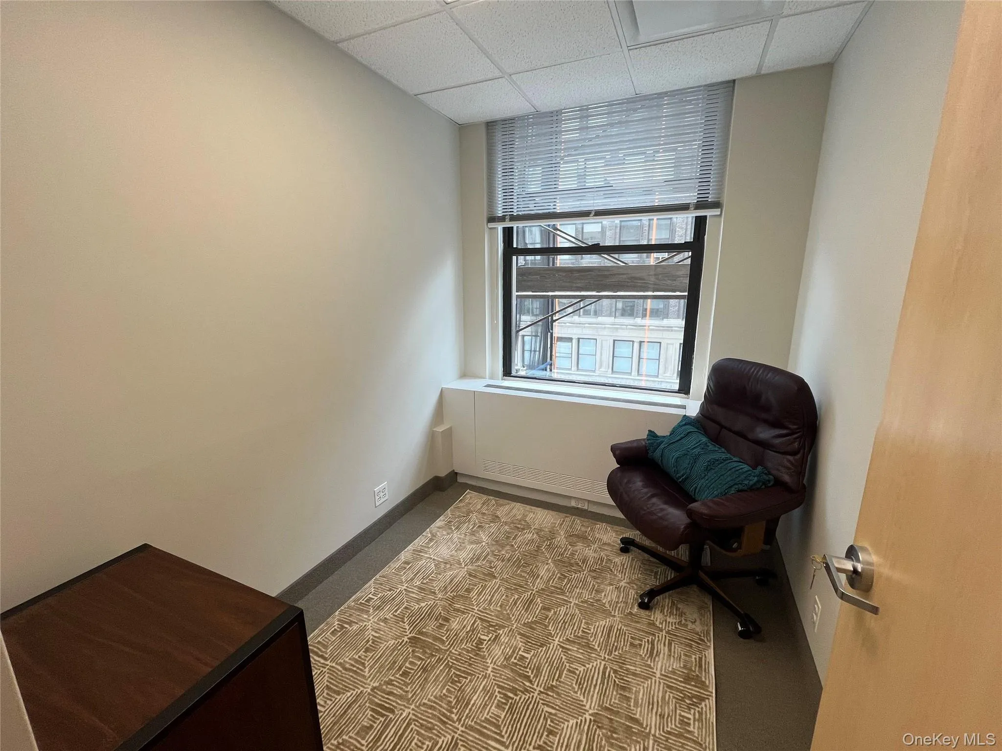 Unfurnished room with light colored carpet and a drop ceiling Unfurnished room with light colored carpet and a drop ceiling