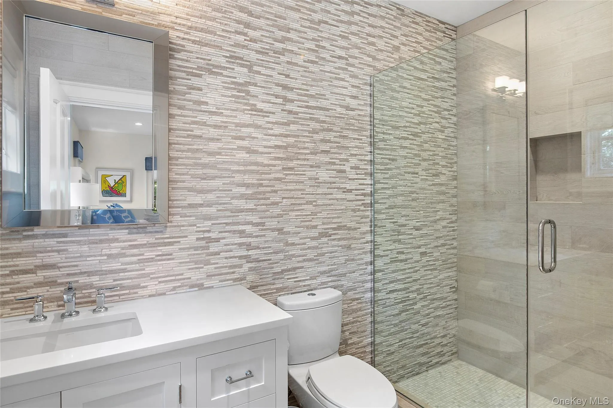 Full bath with tile walls, a stall shower, vanity, and backsplash
