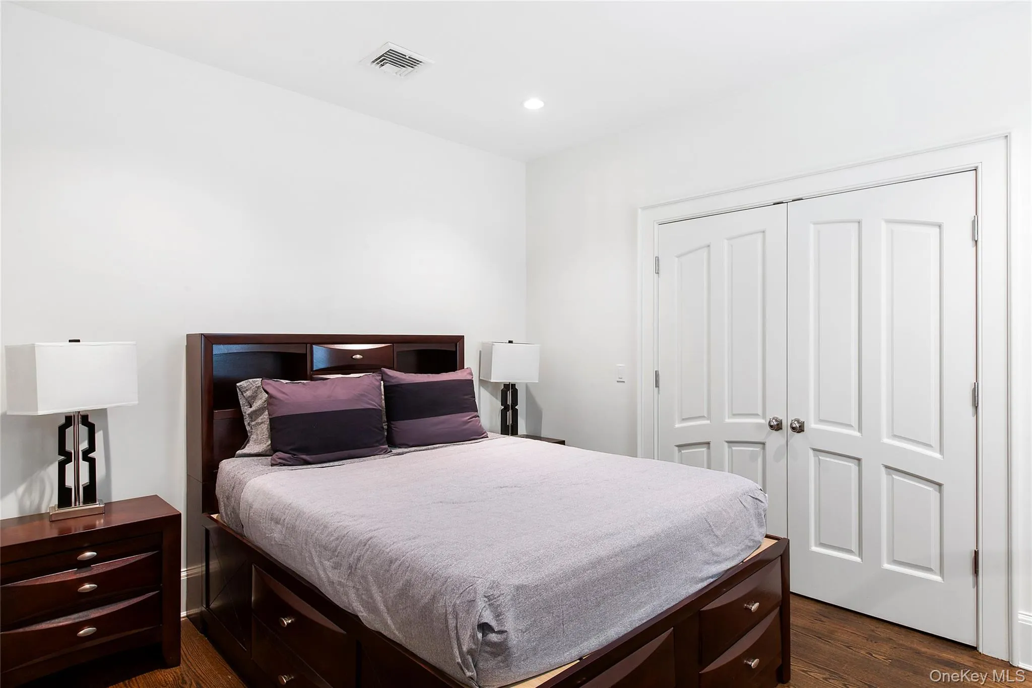 Bedroom with dark wood-type flooring, a closet, and recessed lighting