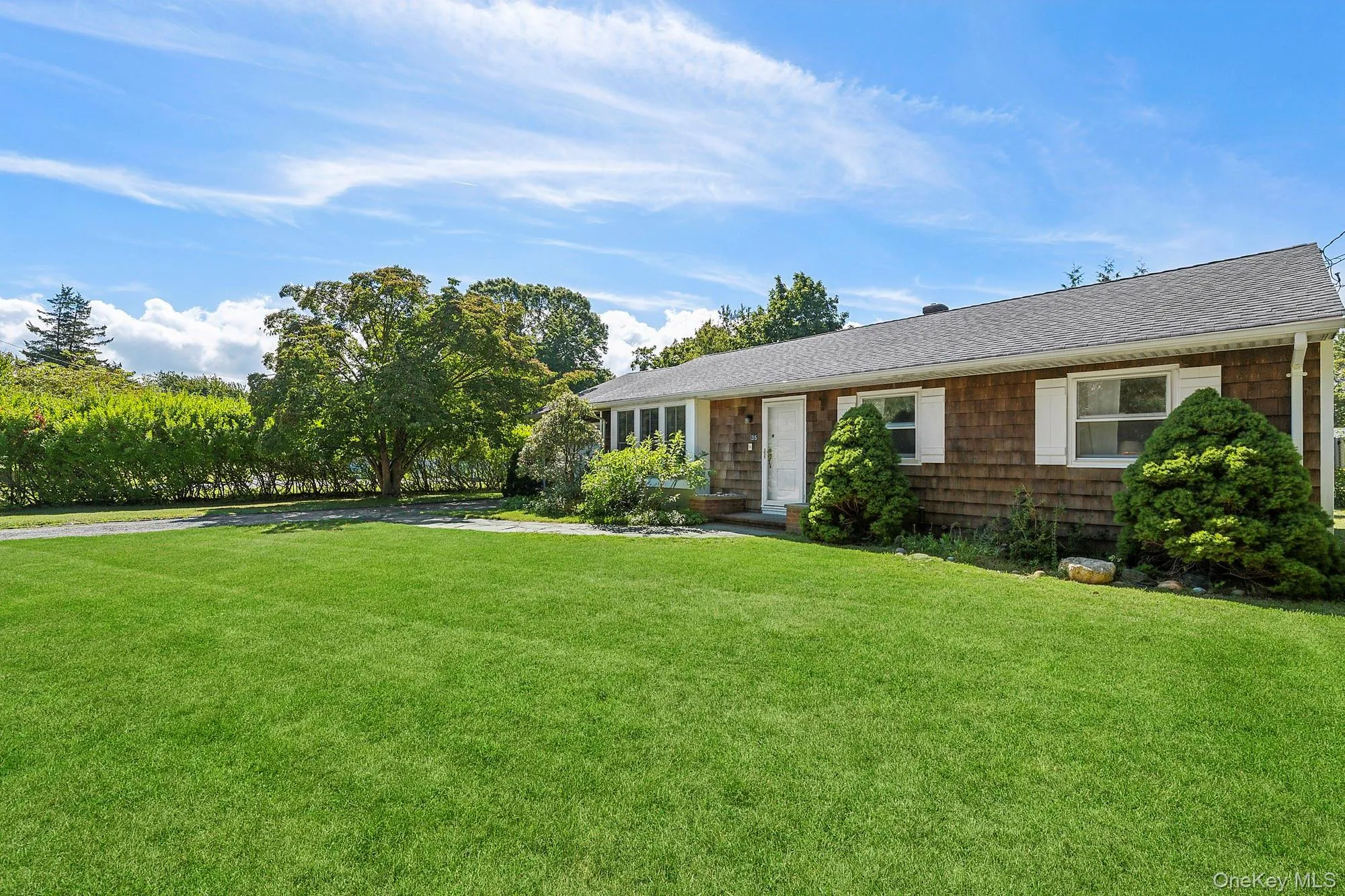 Single story home featuring a front lawn and roof with shingles Single story home featuring a front lawn and roof with shingles