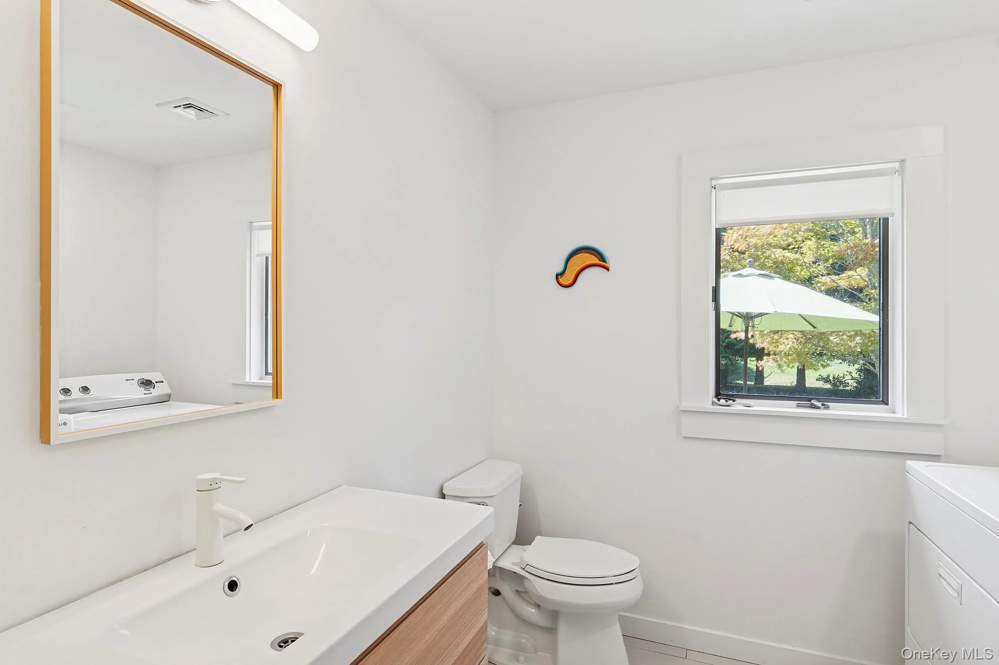 Bathroom featuring vanity, washer / clothes dryer, and tile patterned flooring Bathroom featuring vanity, washer / clothes dryer, and tile patterned flooring