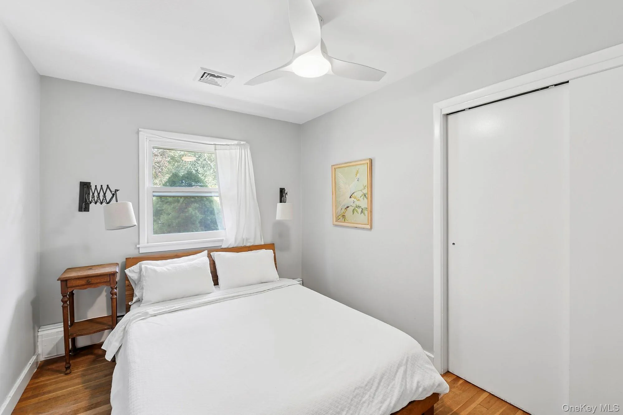 Bedroom with wood finished floors, ceiling fan, and a closet Bedroom with wood finished floors, ceiling fan, and a closet