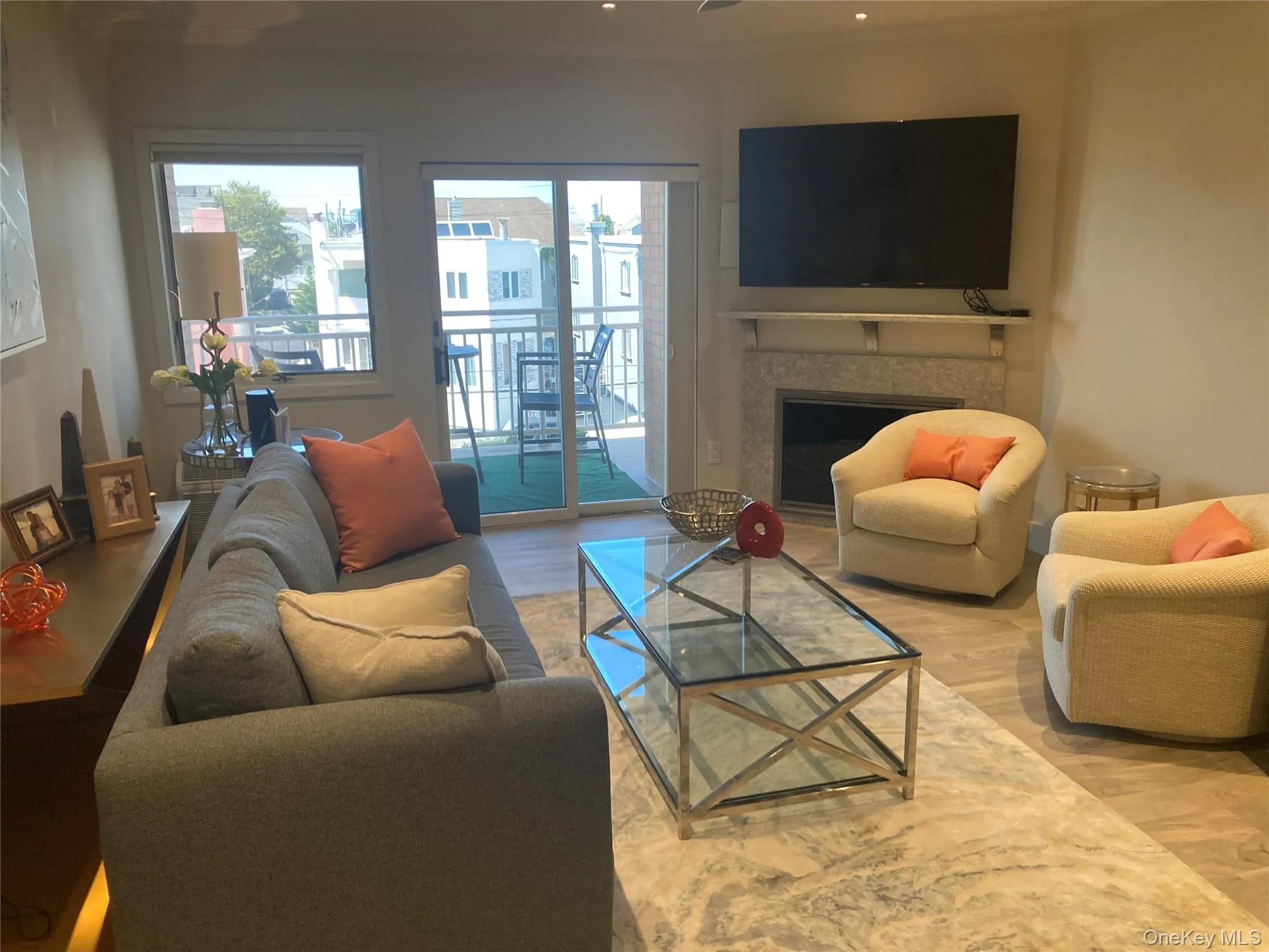 Living room with wood finished floors, a fireplace, and ornamental molding Living room with wood finished floors, a fireplace, and ornamental molding