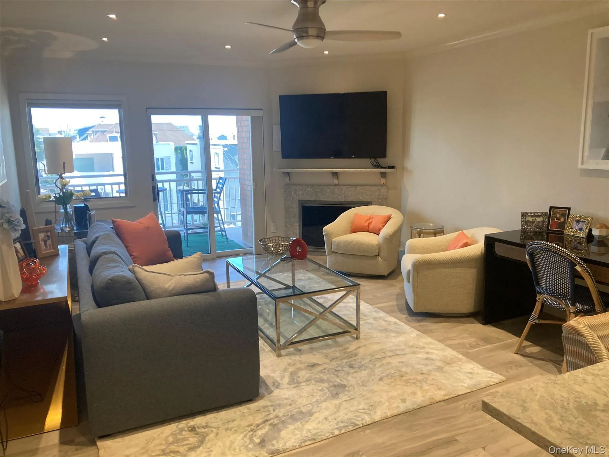 Living room featuring wood finished floors, ornamental molding, a fireplace, recessed lighting, and ceiling fan Living room featuring wood finished floors, ornamental molding, a fireplace, recessed lighting, and ceiling fan