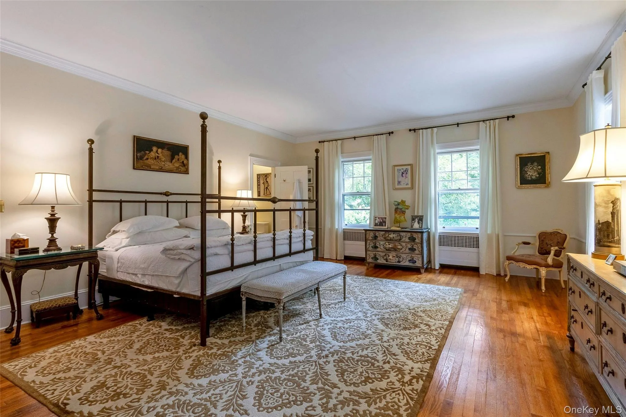 Sun-filled, double exposure primary bedroom with wood floors Sun-filled, double exposure primary bedroom with wood floors