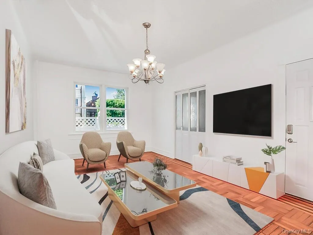 Living area with a chandelier and wood finished floors Living area with a chandelier and wood finished floors
