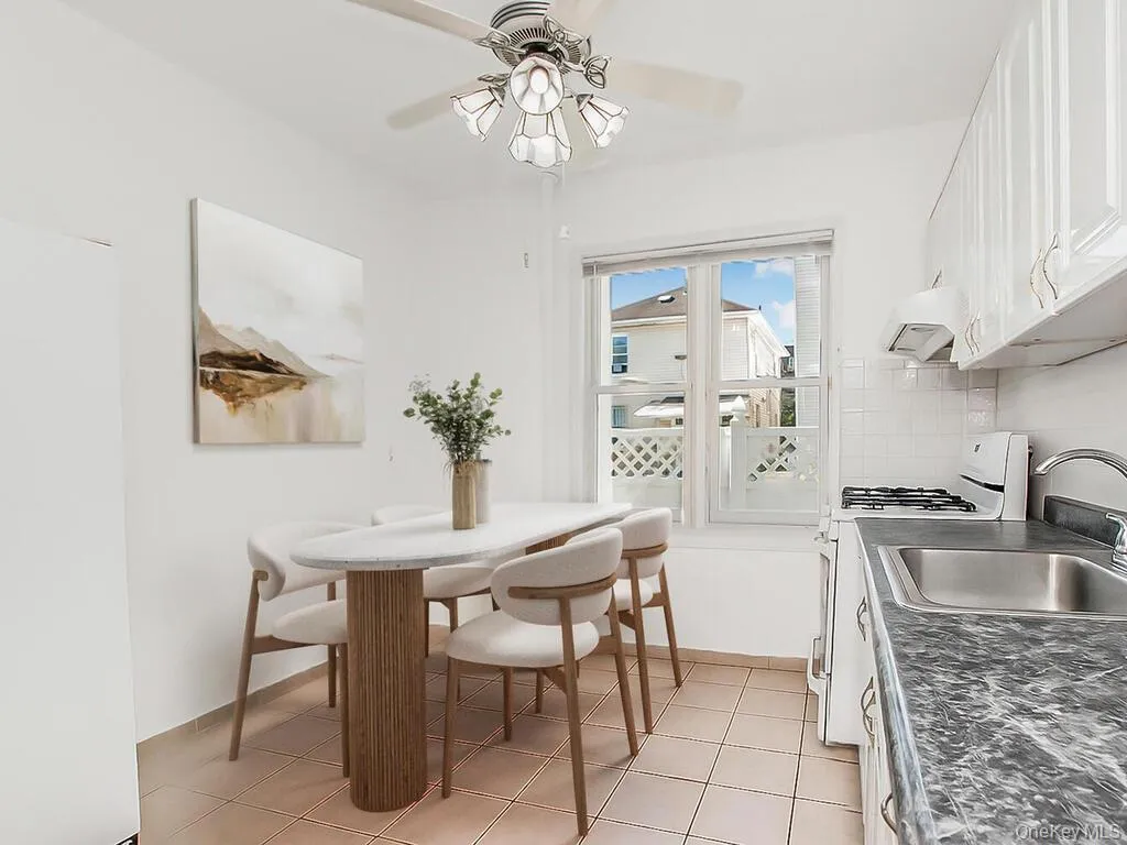 Dining area with light tile patterned floors and a ceiling fan Dining area with light tile patterned floors and a ceiling fan
