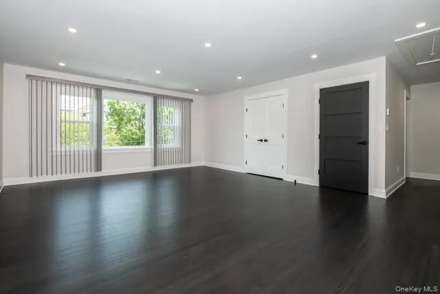 Unfurnished room with attic access, recessed lighting, and dark wood-type flooring Unfurnished room with attic access, recessed lighting, and dark wood-type flooring