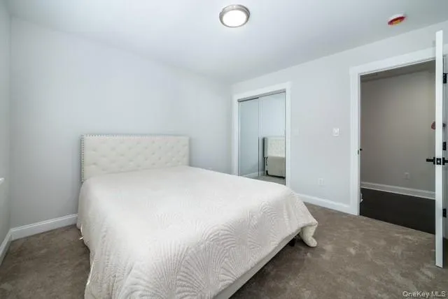 Carpeted bedroom with baseboards and a closet Carpeted bedroom with baseboards and a closet