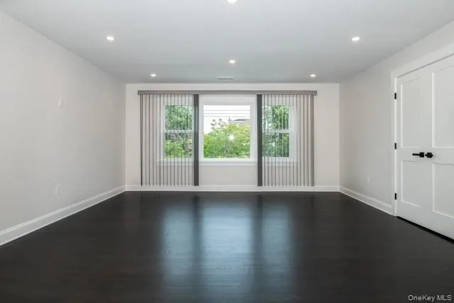 Empty room with recessed lighting and dark wood-style floors Empty room with recessed lighting and dark wood-style floors