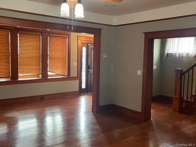 Empty room featuring dark wood finished floors and stairs Empty room featuring dark wood finished floors and stairs