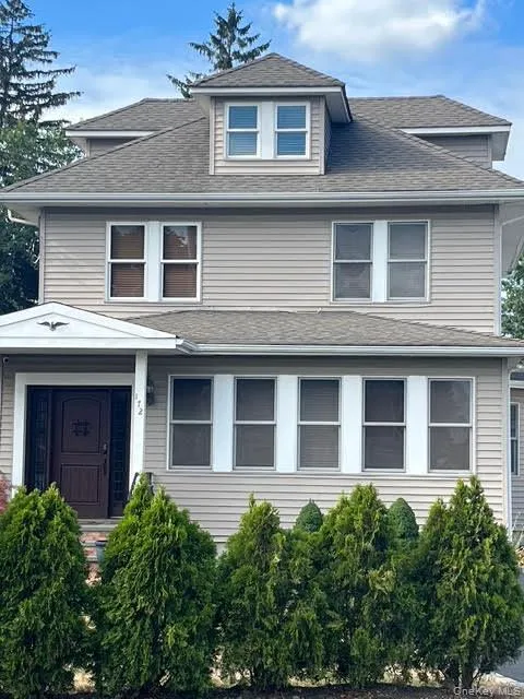 Traditional style home featuring a shingled roof Traditional style home featuring a shingled roof