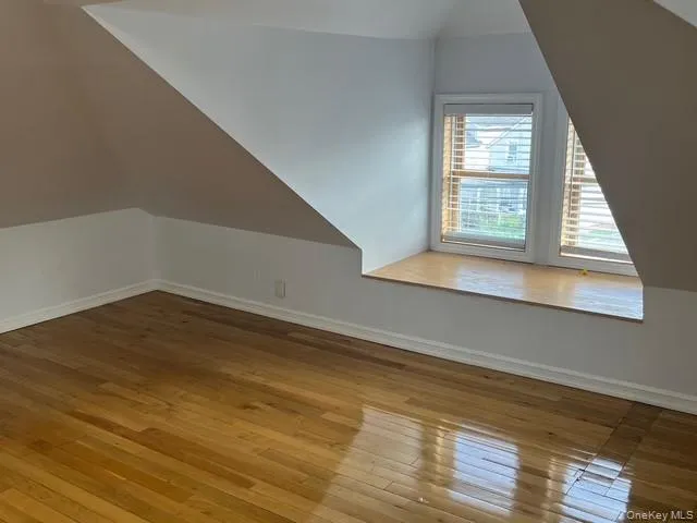 Bonus room featuring vaulted ceiling and hardwood / wood-style flooring Bonus room featuring vaulted ceiling and hardwood / wood-style flooring