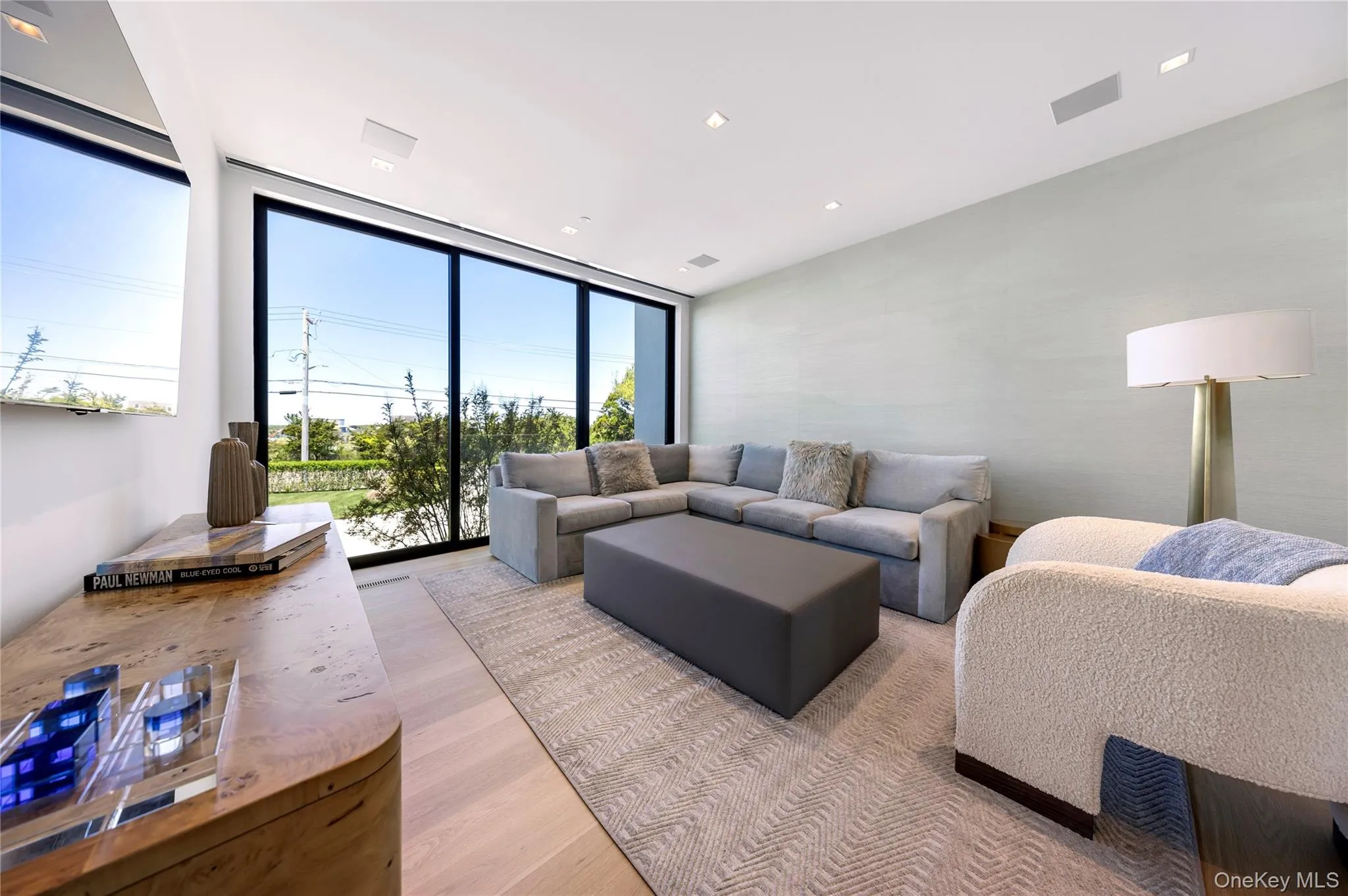 Living room with light wood-style flooring, floor to ceiling windows, and recessed lighting Living room with light wood-style flooring, floor to ceiling windows, and recessed lighting