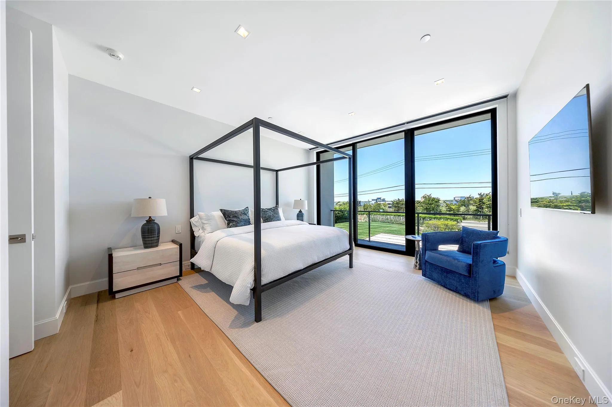 Bedroom with floor to ceiling windows and light wood finished floors Bedroom with floor to ceiling windows and light wood finished floors