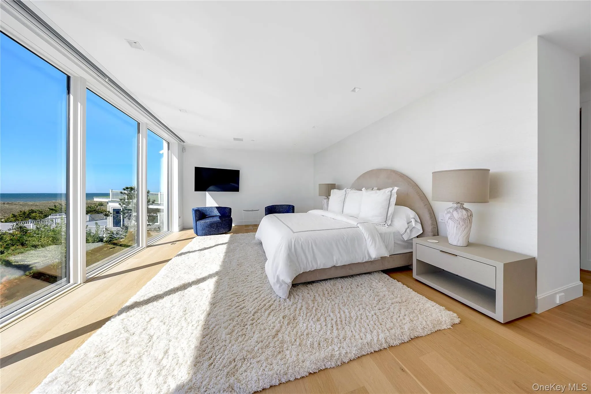 Bedroom featuring light wood-type flooring and a water view Bedroom featuring light wood-type flooring and a water view