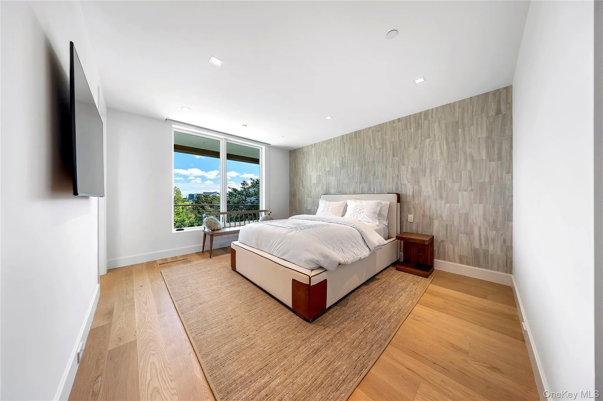 Bedroom featuring an accent wall, light wood finished floors, and recessed lighting Bedroom featuring an accent wall, light wood finished floors, and recessed lighting