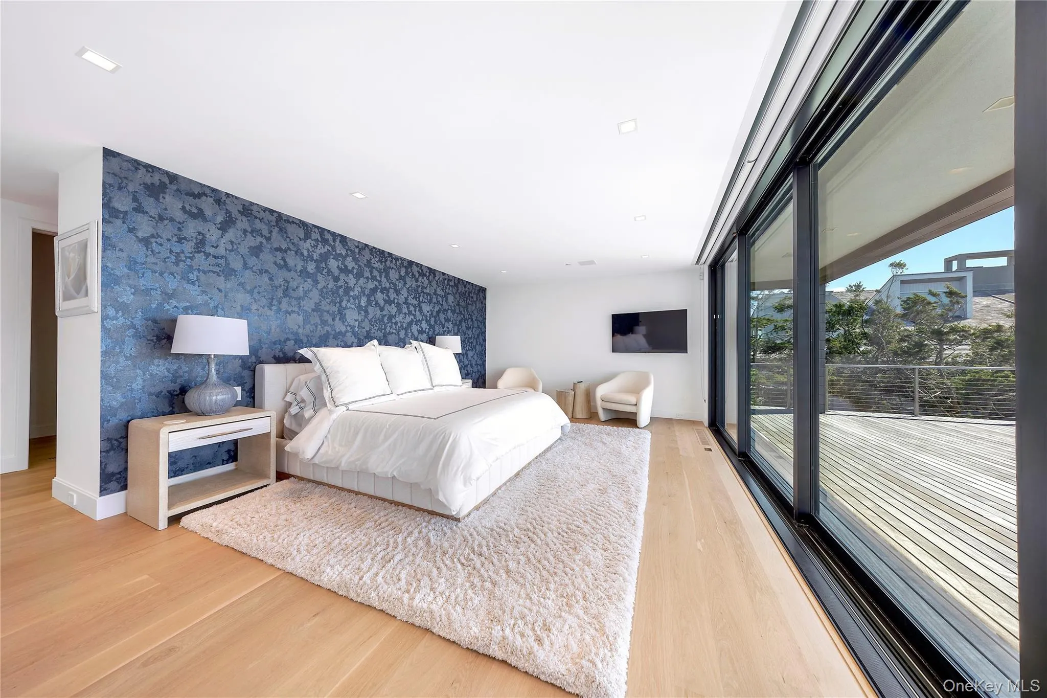 Bedroom featuring wallpapered walls, light wood-type flooring, an accent wall, recessed lighting, and access to outside Bedroom featuring wallpapered walls, light wood-type flooring, an accent wall, recessed lighting, and access to outside