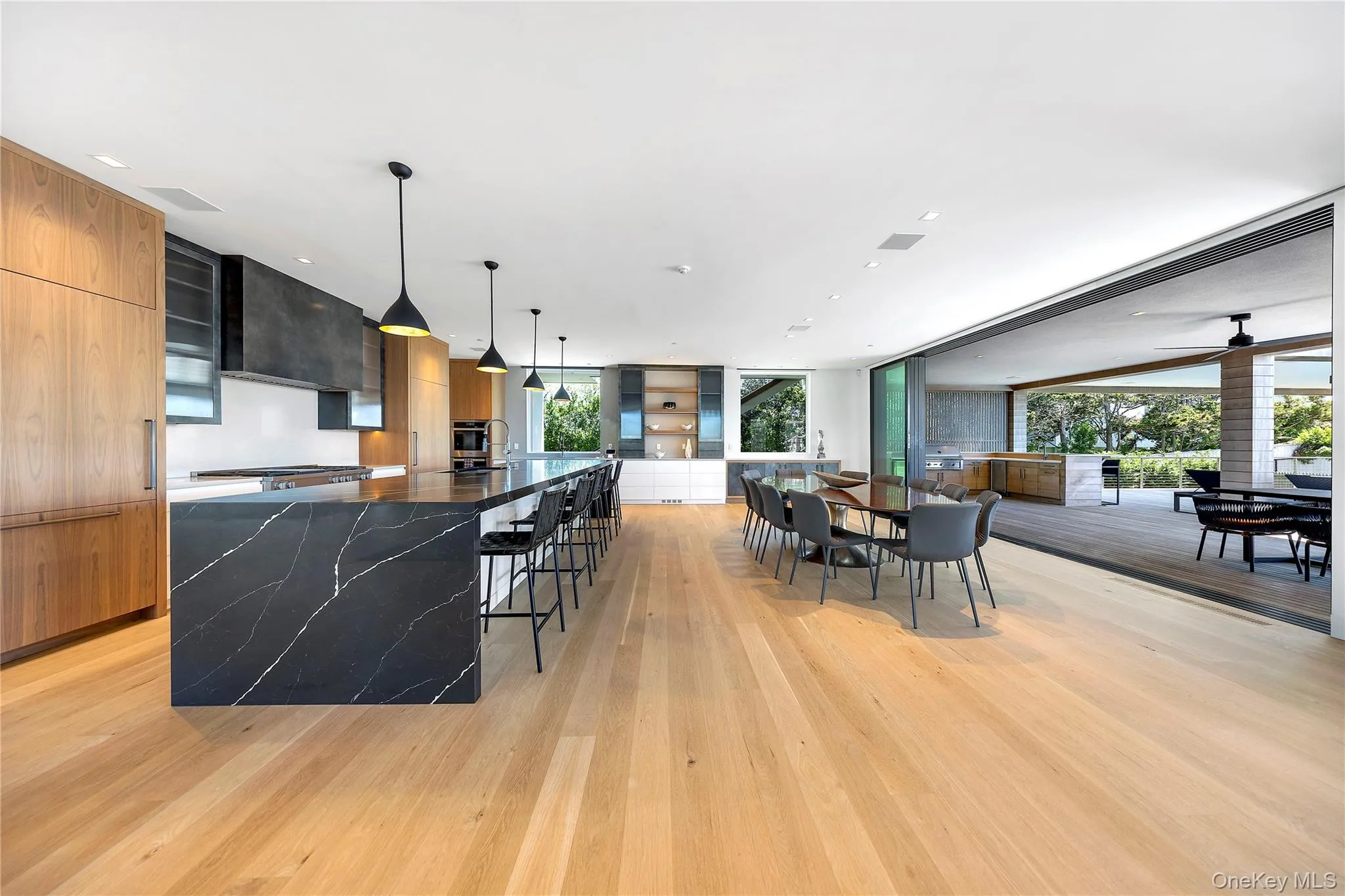 Kitchen featuring modern cabinets, a breakfast bar, healthy amount of natural light, a large island, and a wall of windows Kitchen featuring modern cabinets, a breakfast bar, healthy amount of natural light, a large island, and a wall of windows