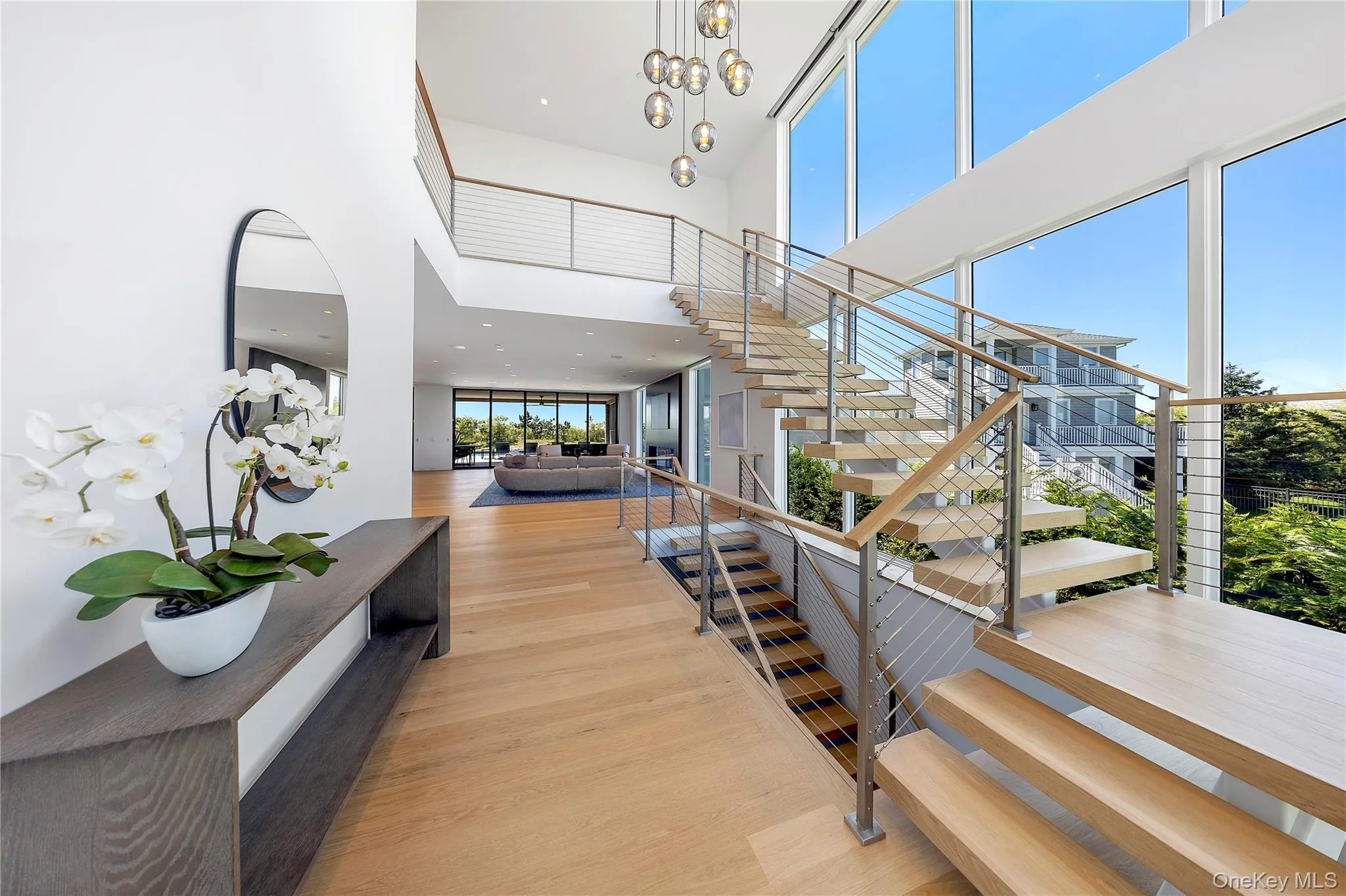 Staircase with a high ceiling, wood finished floors, a chandelier, and recessed lighting Staircase with a high ceiling, wood finished floors, a chandelier, and recessed lighting