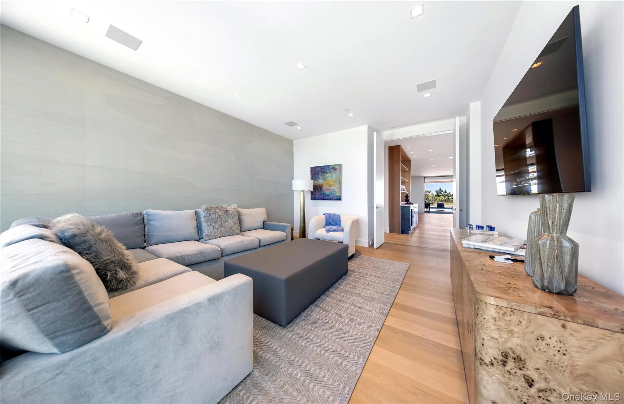 Living area with light wood-style floors and recessed lighting Living area with light wood-style floors and recessed lighting