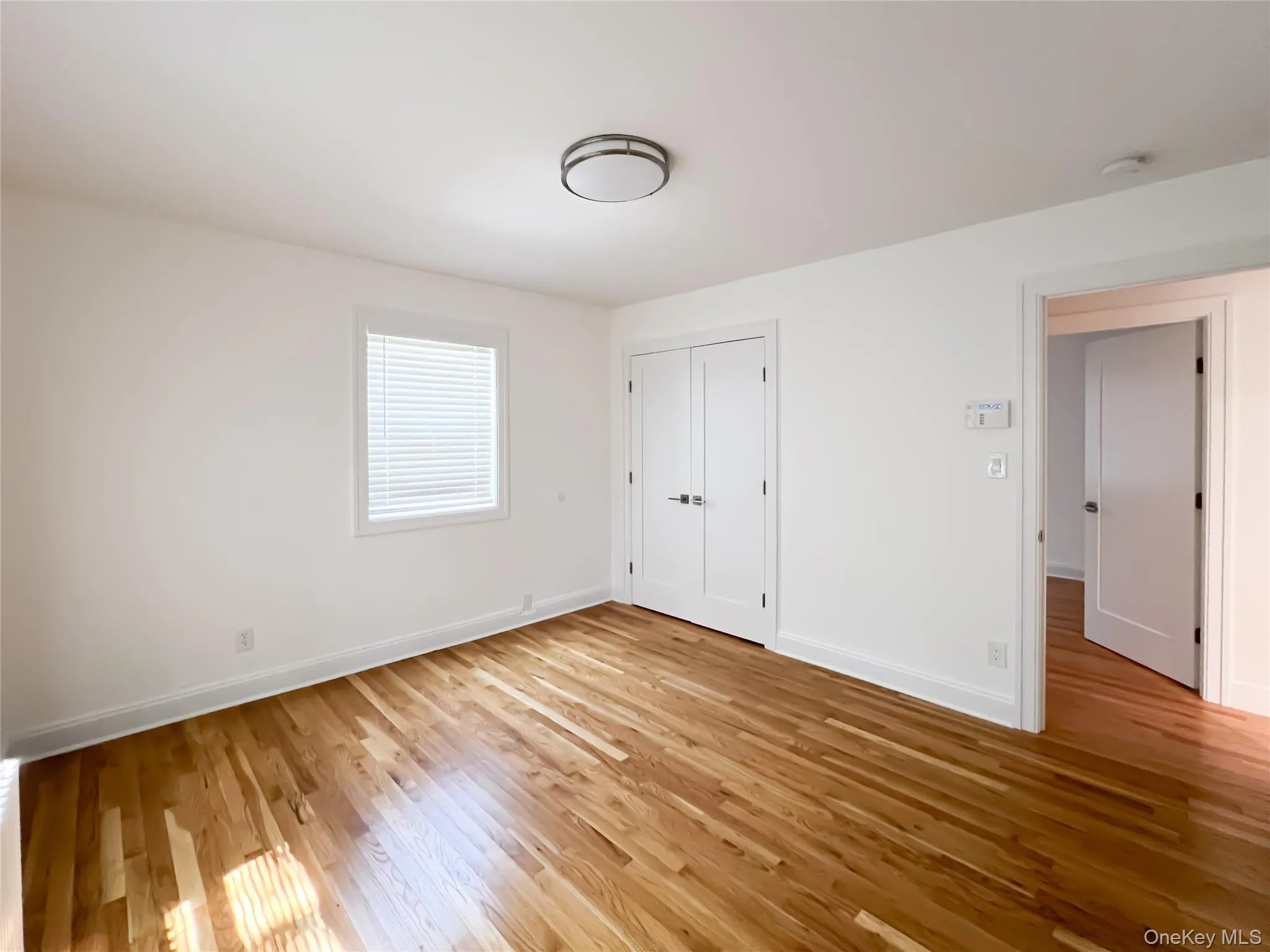 Unfurnished bedroom with light wood-type flooring and a closet Unfurnished bedroom with light wood-type flooring and a closet