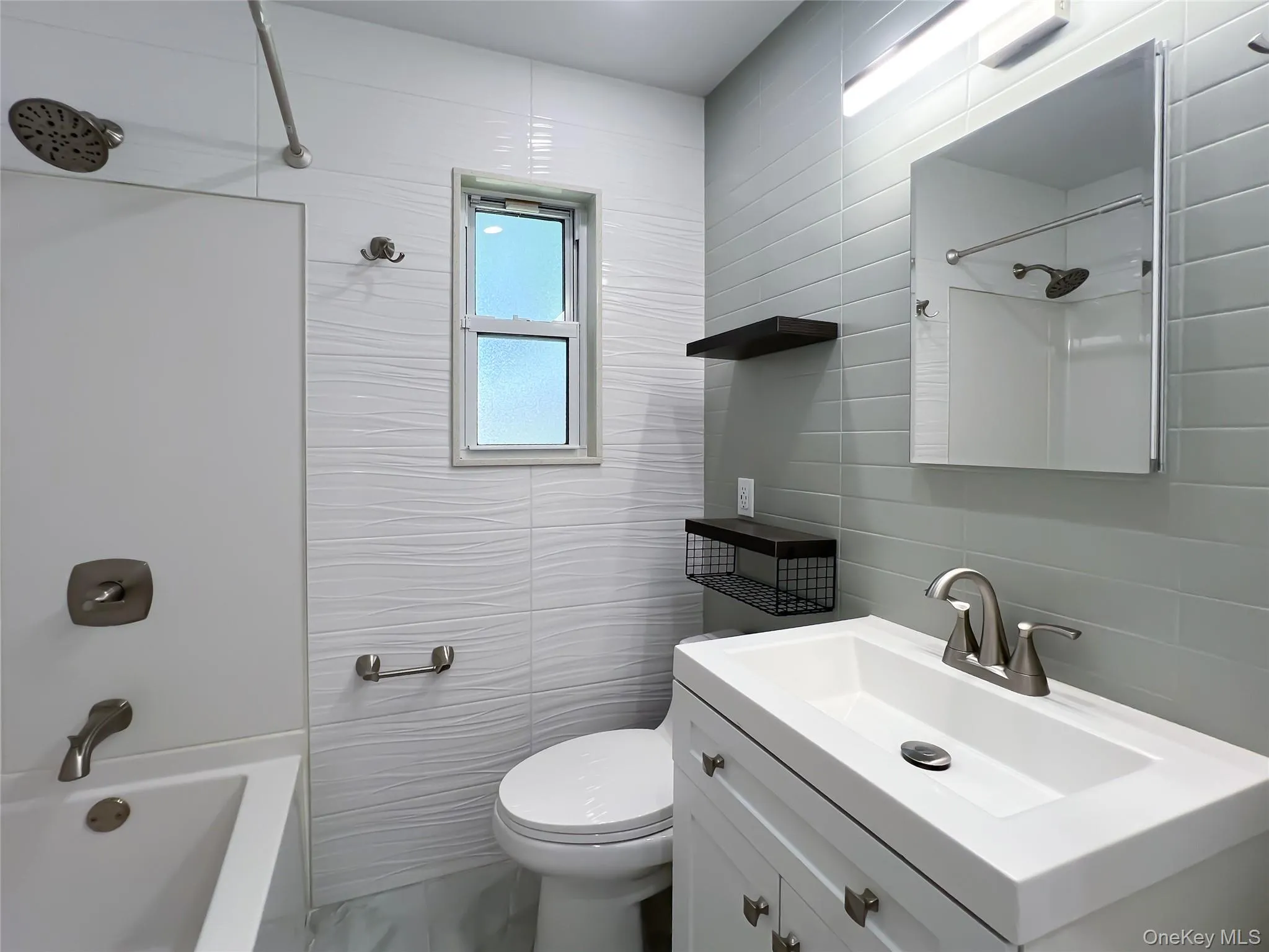 Bathroom with tile walls, shower / bath combination, and vanity Bathroom with tile walls, shower / bath combination, and vanity