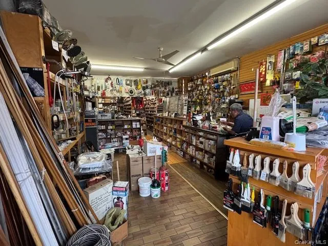 Miscellaneous room featuring dark wood finished floors, a ceiling fan, and a workshop area Miscellaneous room featuring dark wood finished floors, a ceiling fan, and a workshop area