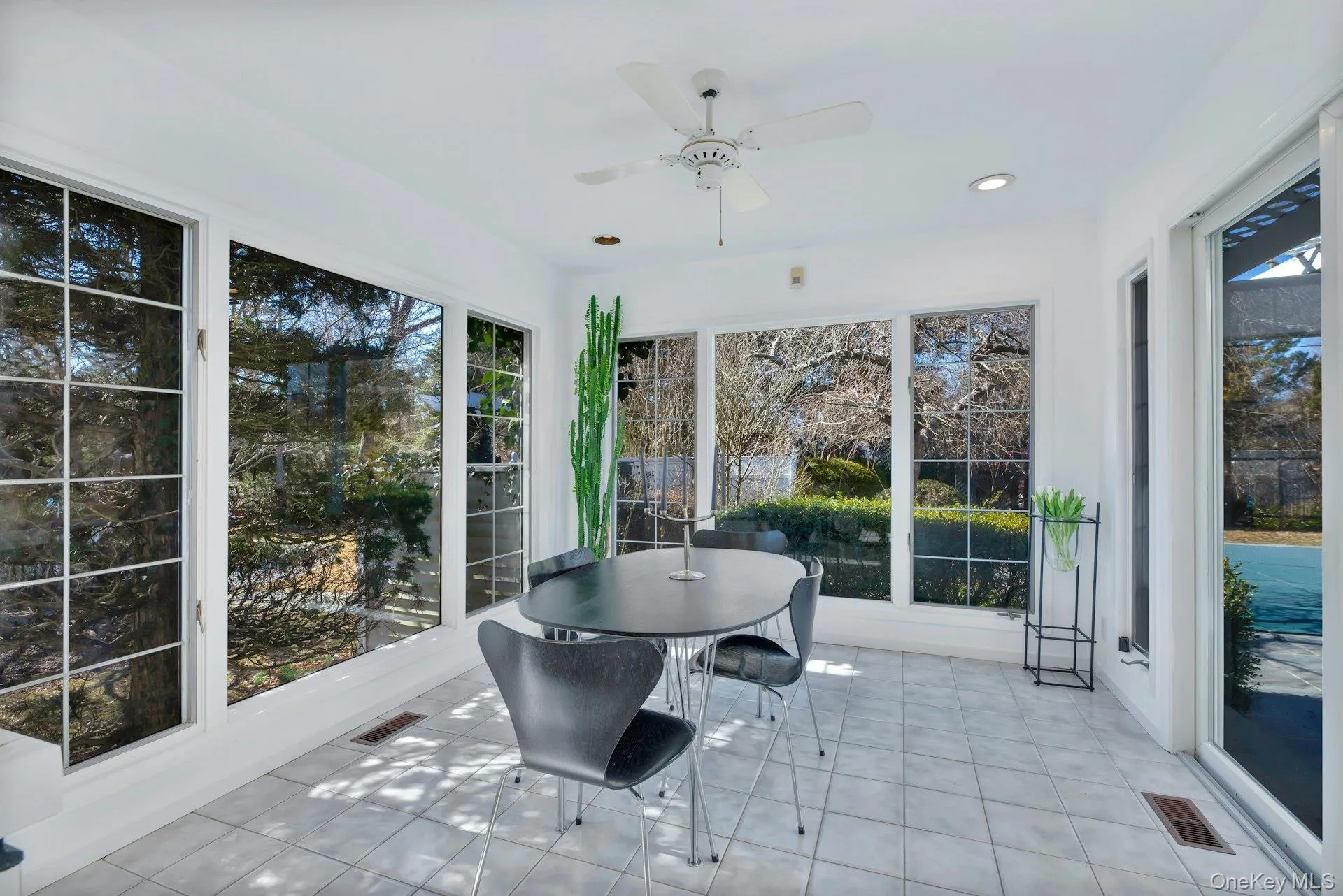 Dining Area off Kitchen- Features of Sunroom/Solarium featuring ceiling fan with glass sliders to Patio, Pool, Tennis & Backyard Dining Area off Kitchen- Features of Sunroom/Solarium featuring ceiling fan with glass sliders to Patio, Pool, Tennis & Backyard