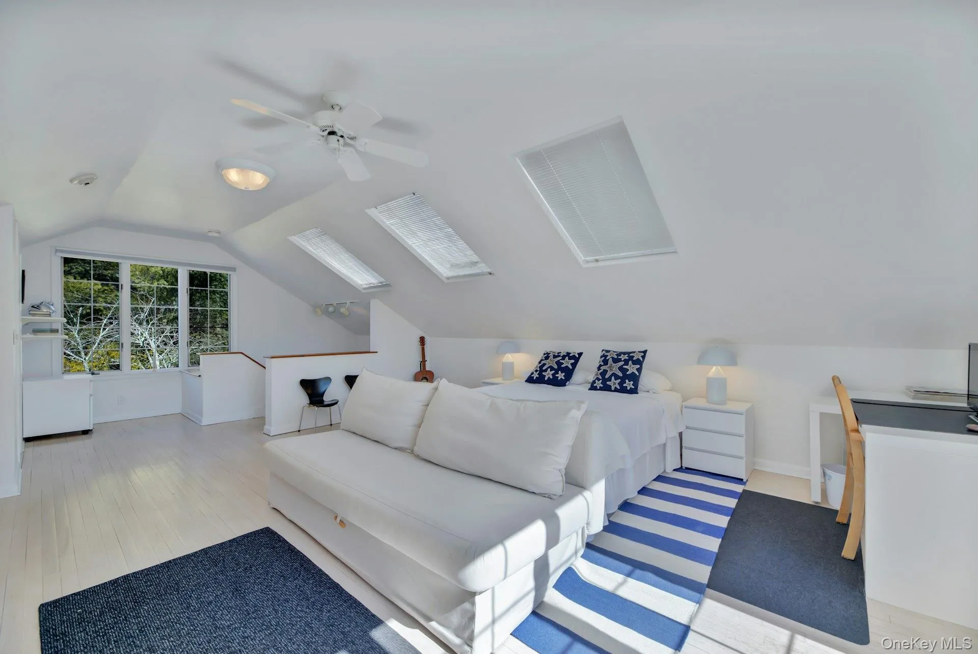 Bedroom with focus on desk area with park like views lofted ceiling, ceiling fan, wood finished floors, and baseboards Bedroom with focus on desk area with park like views lofted ceiling, ceiling fan, wood finished floors, and baseboards