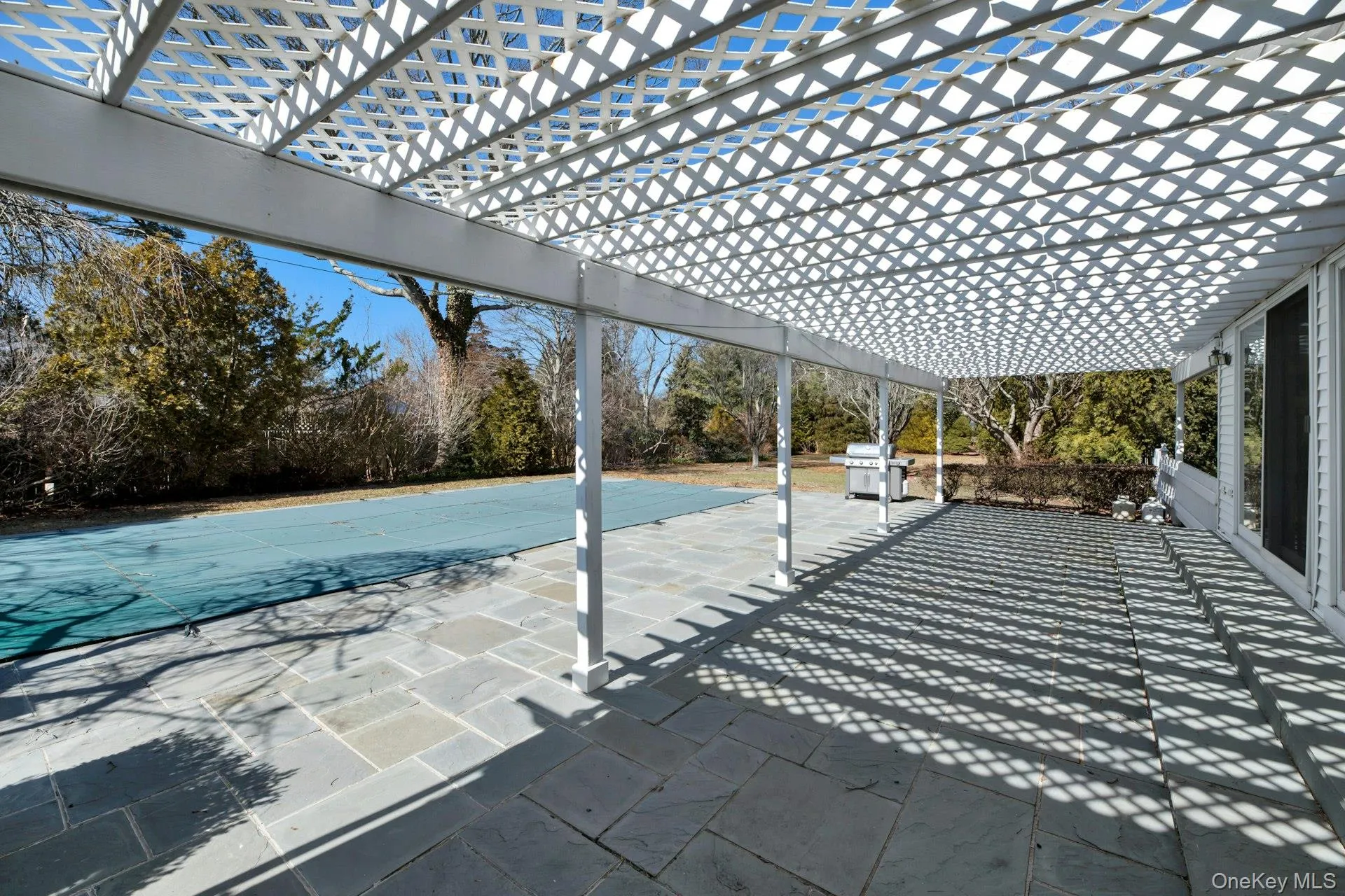 Patio flanking great room with glass slider access to interior. View of patio featuring grilling area and a pergola Patio flanking great room with glass slider access to interior. View of patio featuring grilling area and a pergola