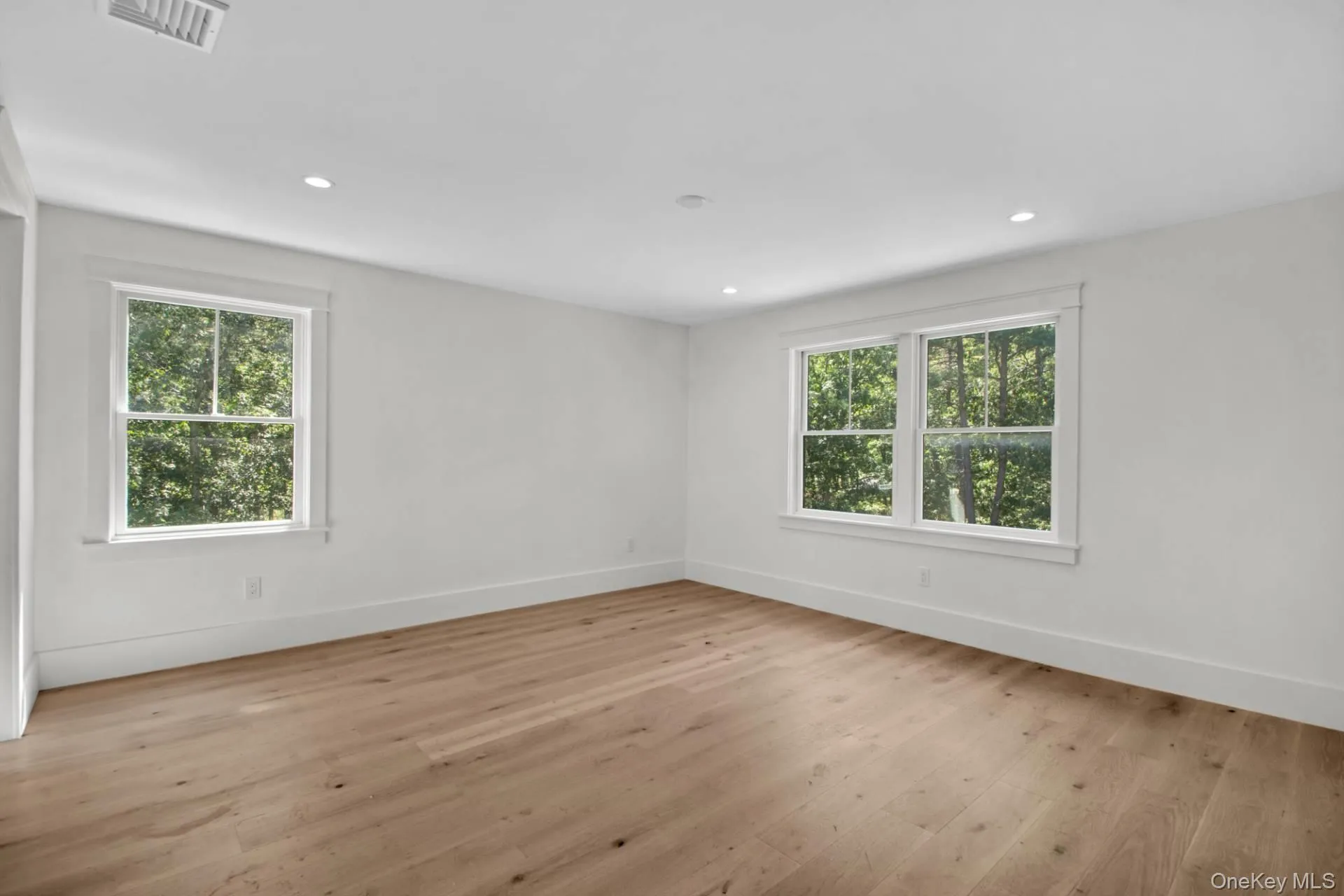 Empty room with light wood-type flooring and recessed lighting Empty room with light wood-type flooring and recessed lighting