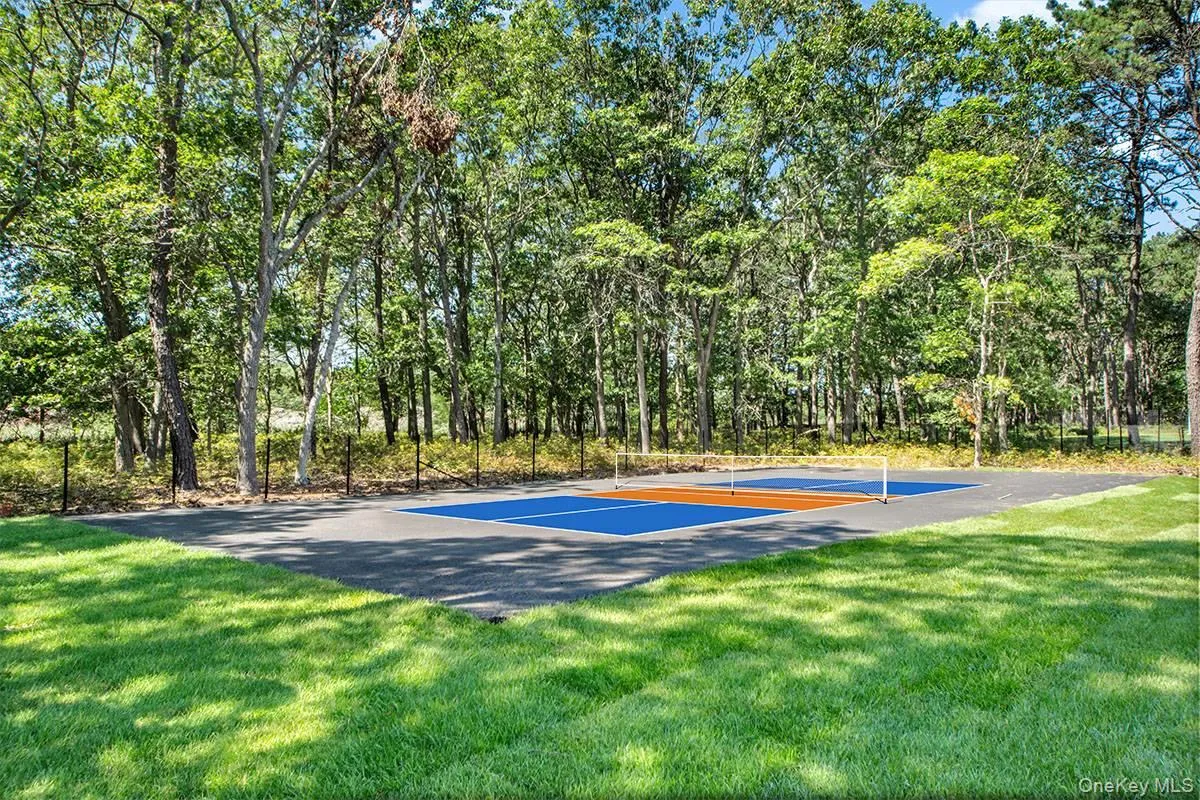 View of pickleball court featuring a lawn View of pickleball court featuring a lawn