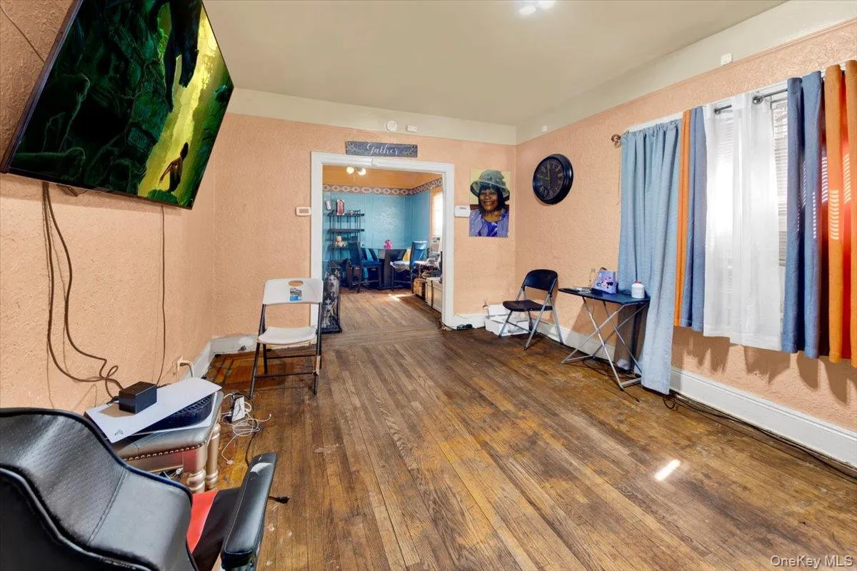 Home office with a textured wall and dark wood-style flooring Home office with a textured wall and dark wood-style flooring