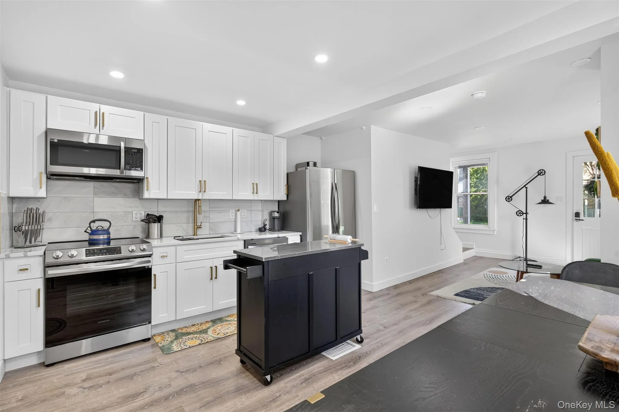 Kitchen featuring stainless steel appliances, stone countertops, island and clean, modern finishes Kitchen featuring stainless steel appliances, stone countertops, island and clean, modern finishes