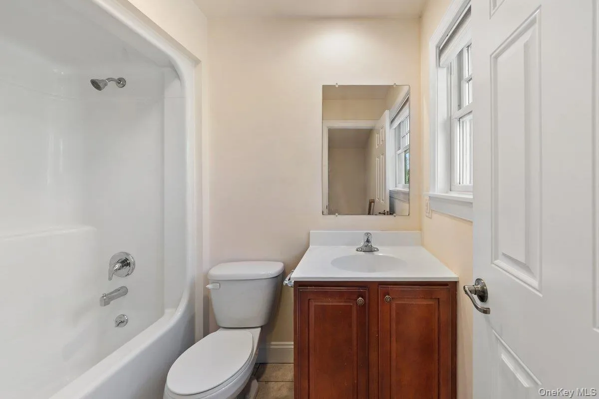 Full bathroom featuring tub / shower combination, vanity, and tile patterned floors Full bathroom featuring tub / shower combination, vanity, and tile patterned floors
