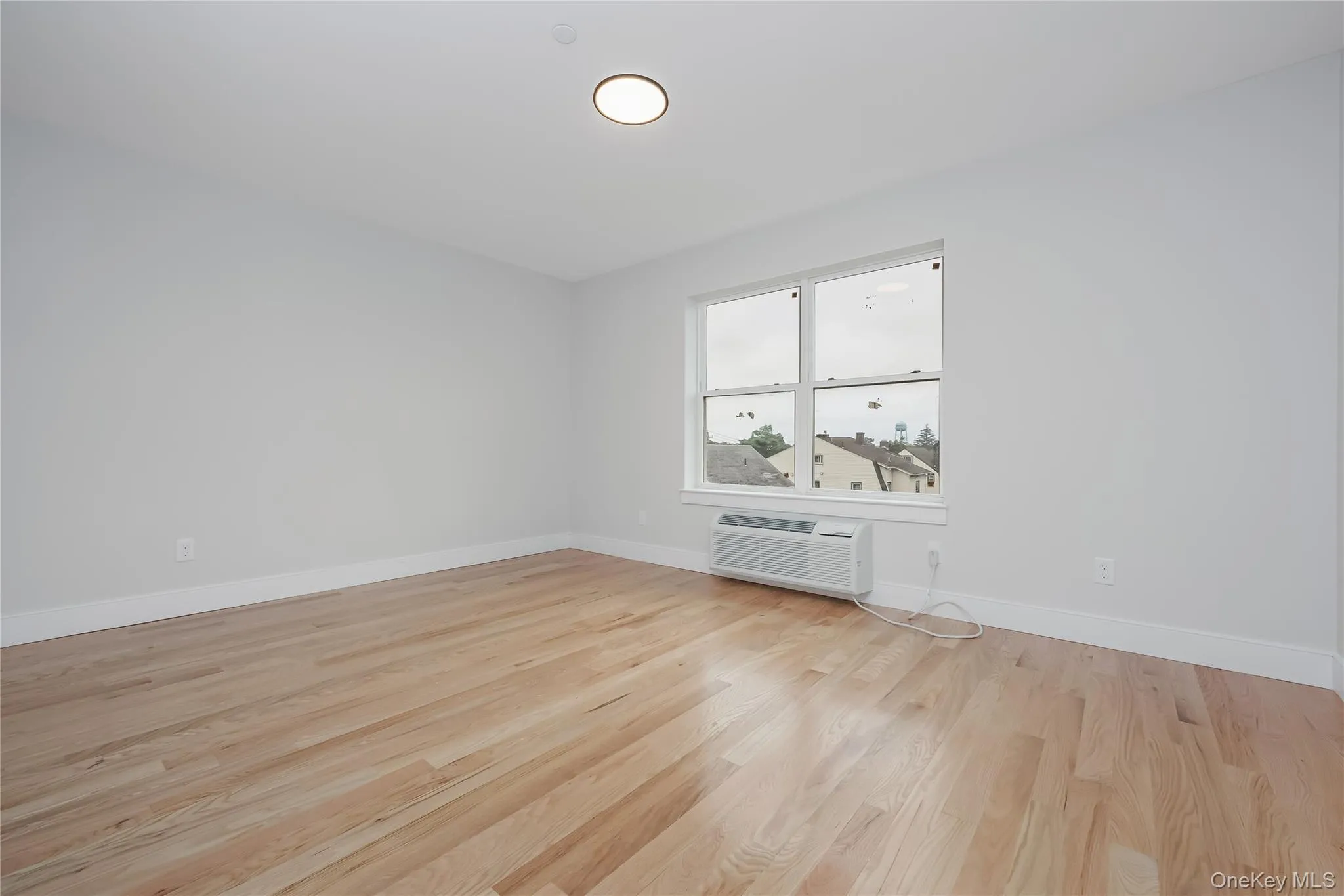 Spare room with light wood-type flooring and baseboards Spare room with light wood-type flooring and baseboards