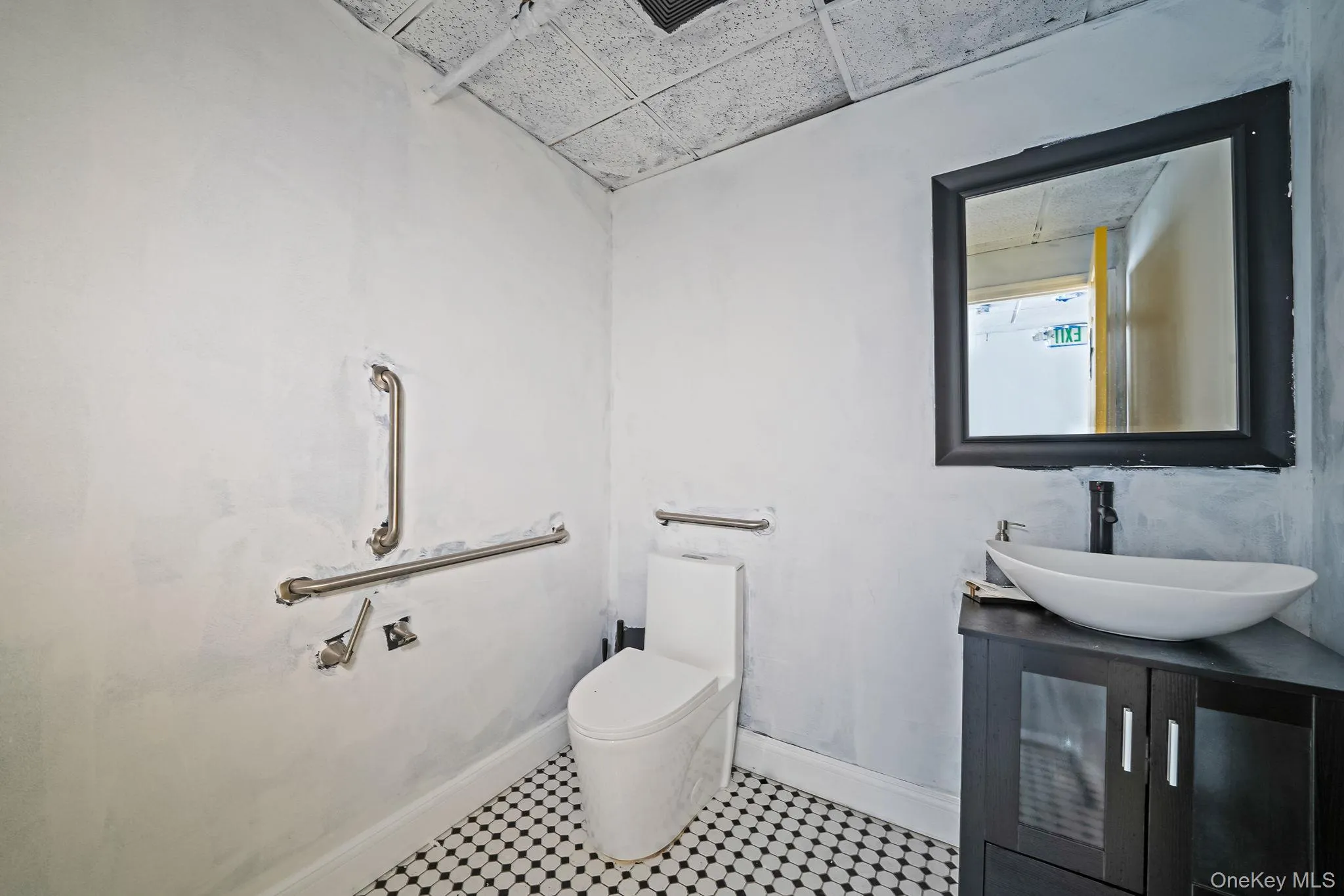 Half bathroom featuring vanity and a drop ceiling Half bathroom featuring vanity and a drop ceiling