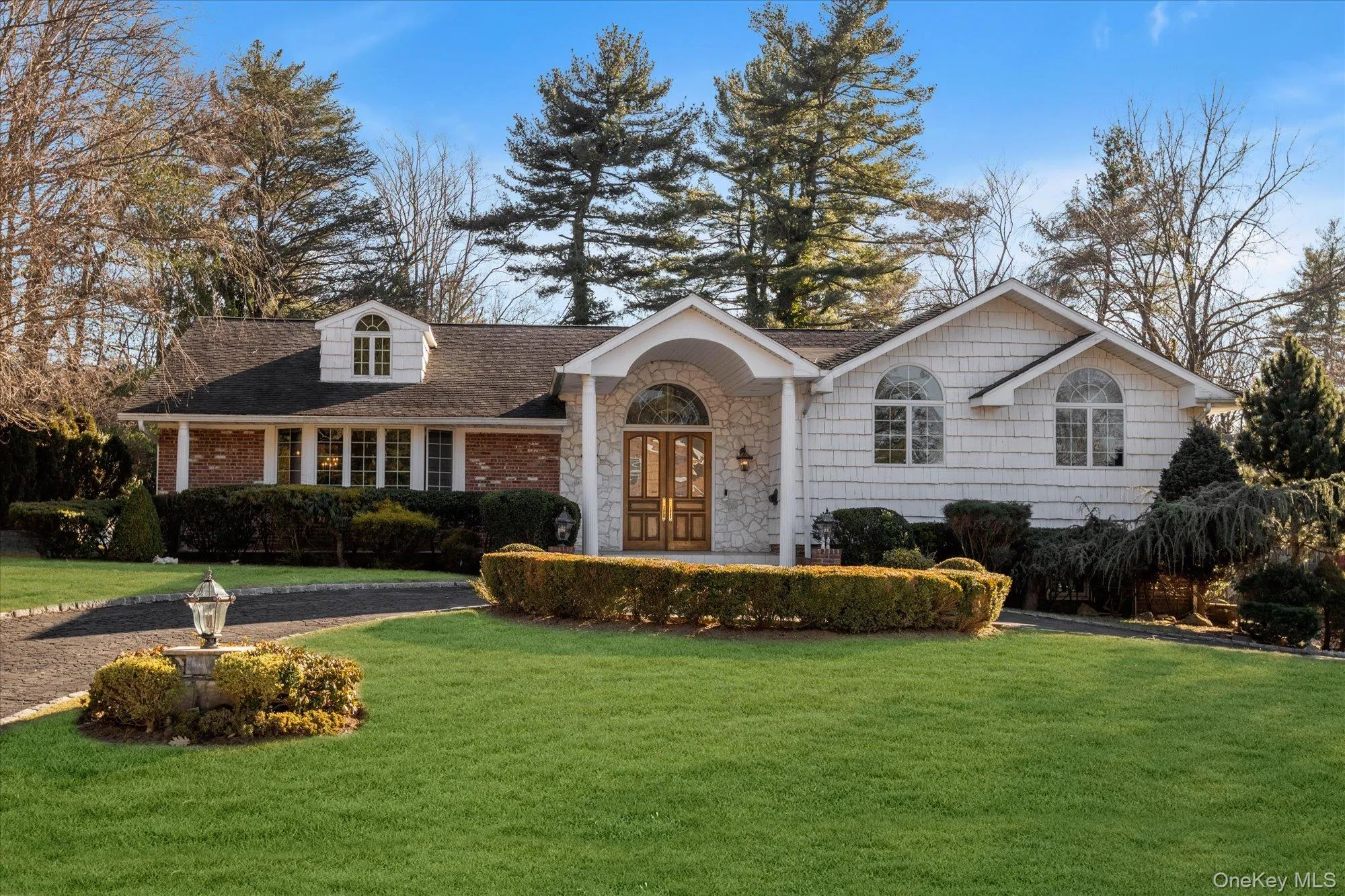 View of front of home featuring a front yard, roof with shingles, french doors, and stone siding View of front of home featuring a front yard, roof with shingles, french doors, and stone siding