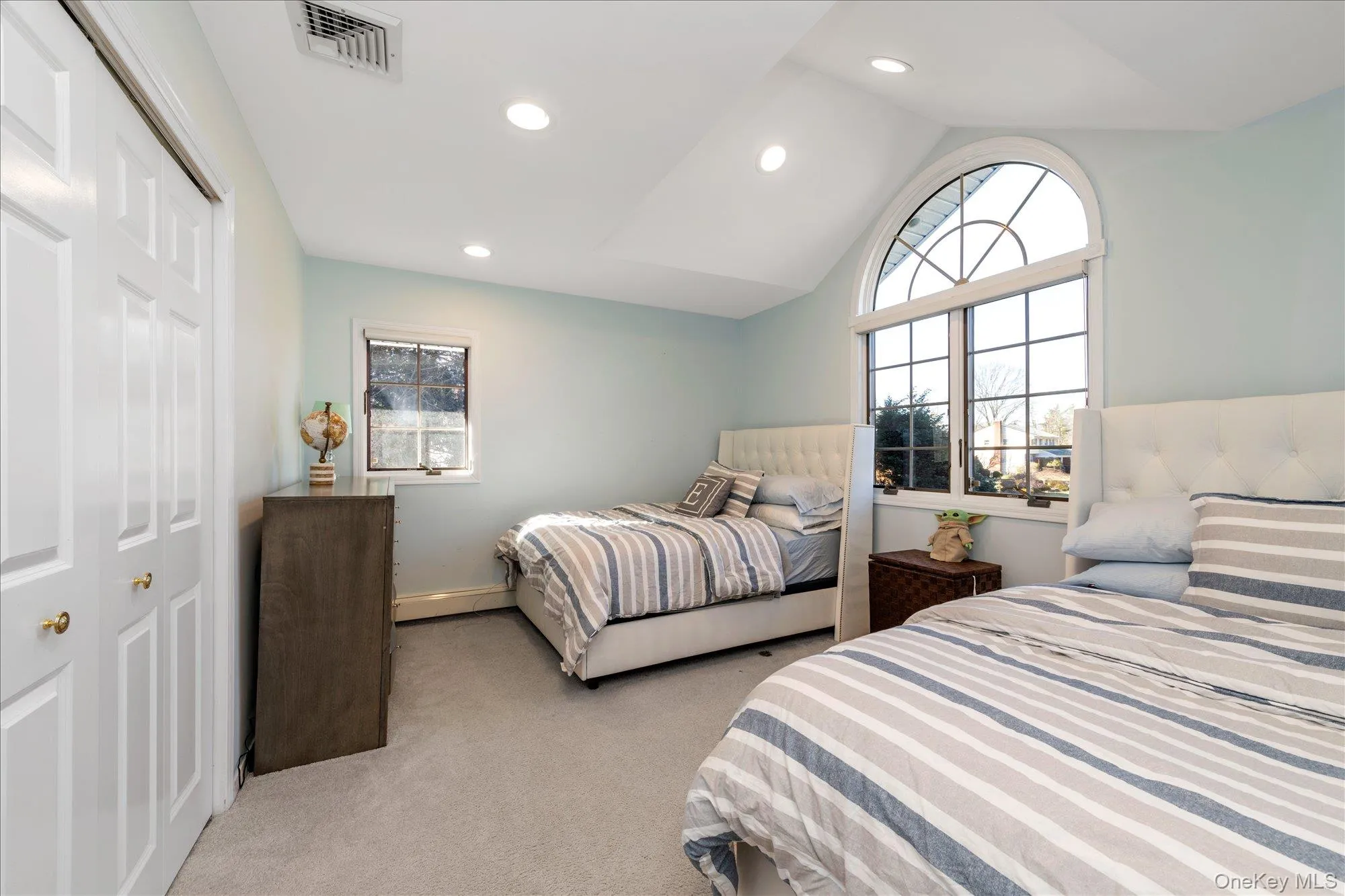 Bedroom featuring multiple windows, lofted ceiling, light colored carpet, recessed lighting, and a closet Bedroom featuring multiple windows, lofted ceiling, light colored carpet, recessed lighting, and a closet