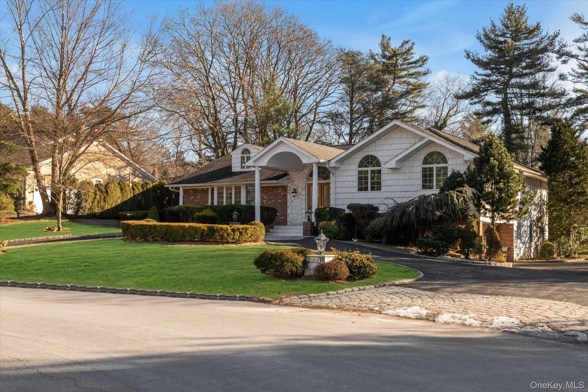 Split foyer home featuring asphalt driveway, a front lawn, and brick siding Split foyer home featuring asphalt driveway, a front lawn, and brick siding