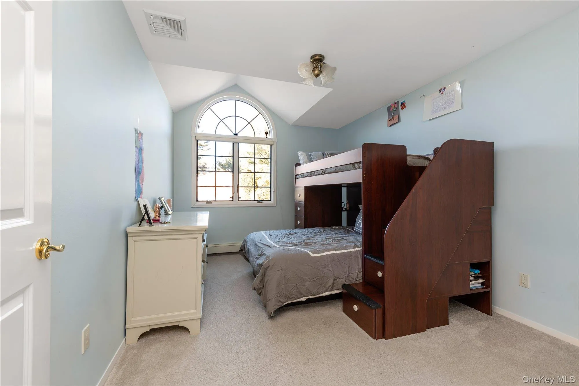 Bedroom featuring lofted ceiling, light colored carpet, and a baseboard radiator Bedroom featuring lofted ceiling, light colored carpet, and a baseboard radiator