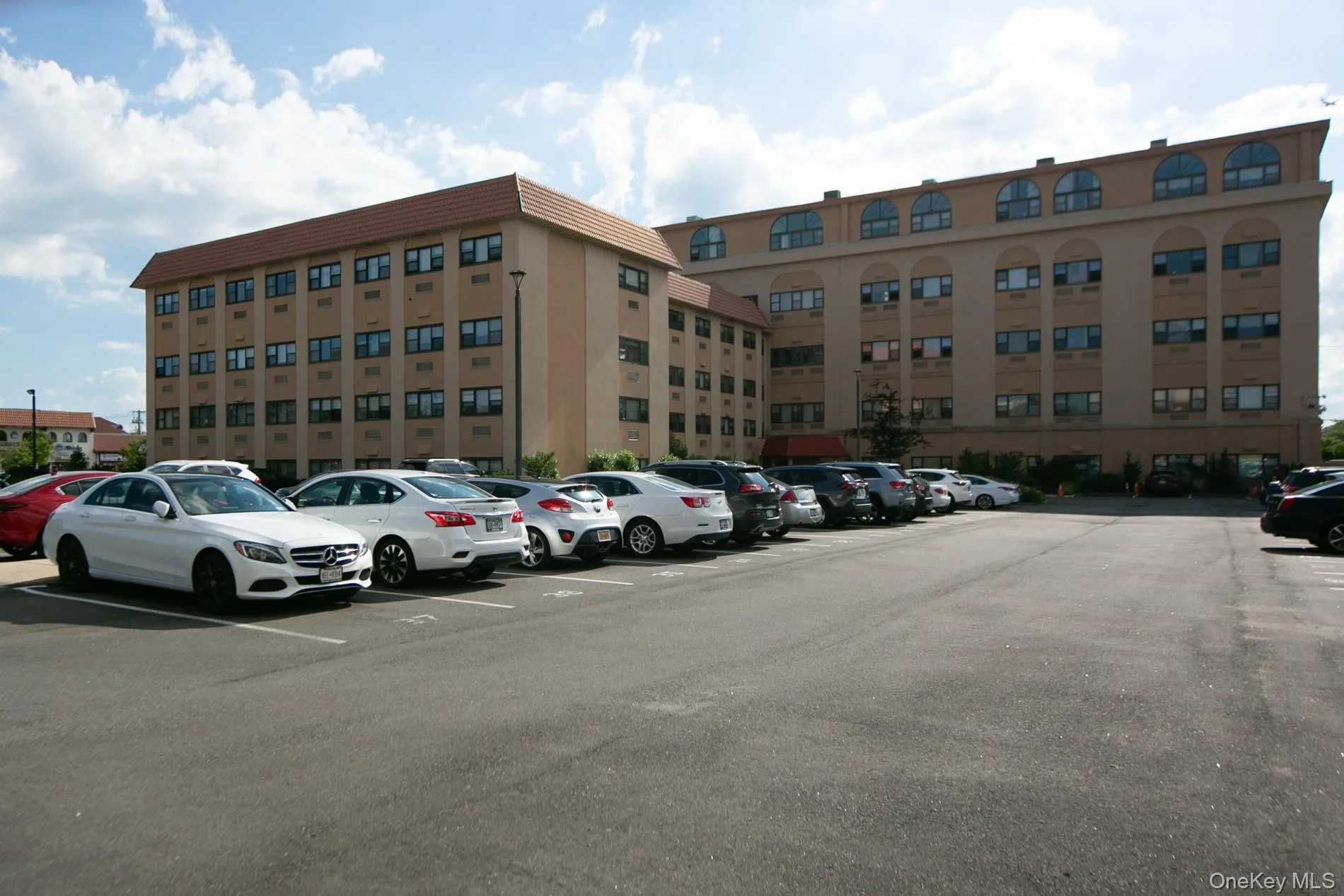 View of building exterior featuring uncovered parking View of building exterior featuring uncovered parking