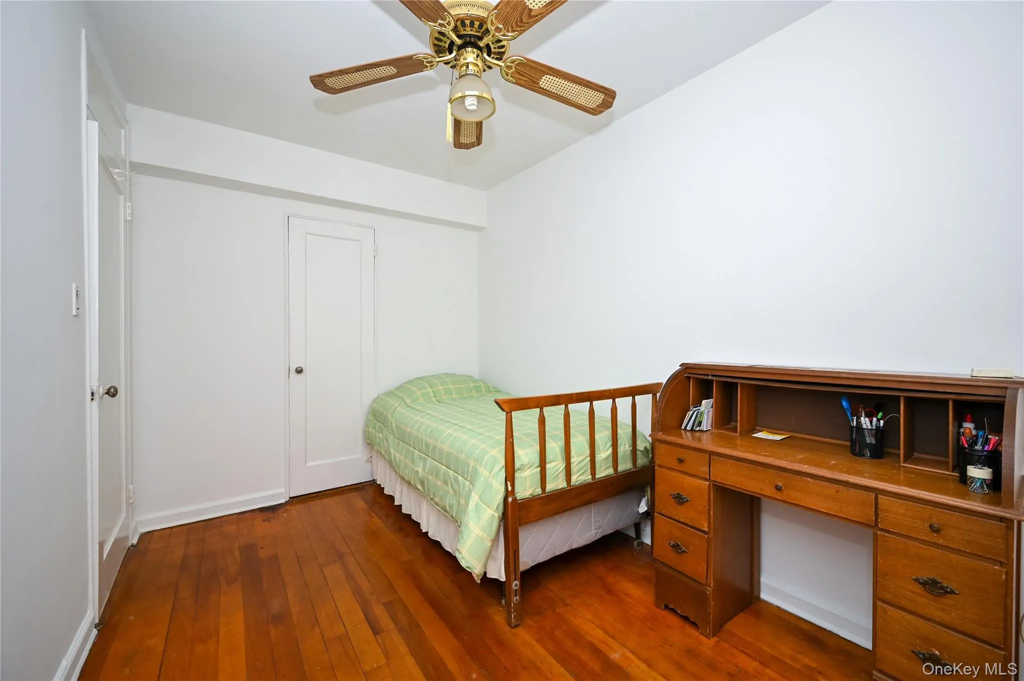 Bedroom featuring dark wood-style floors, ceiling fan, and an office area Bedroom featuring dark wood-style floors, ceiling fan, and an office area