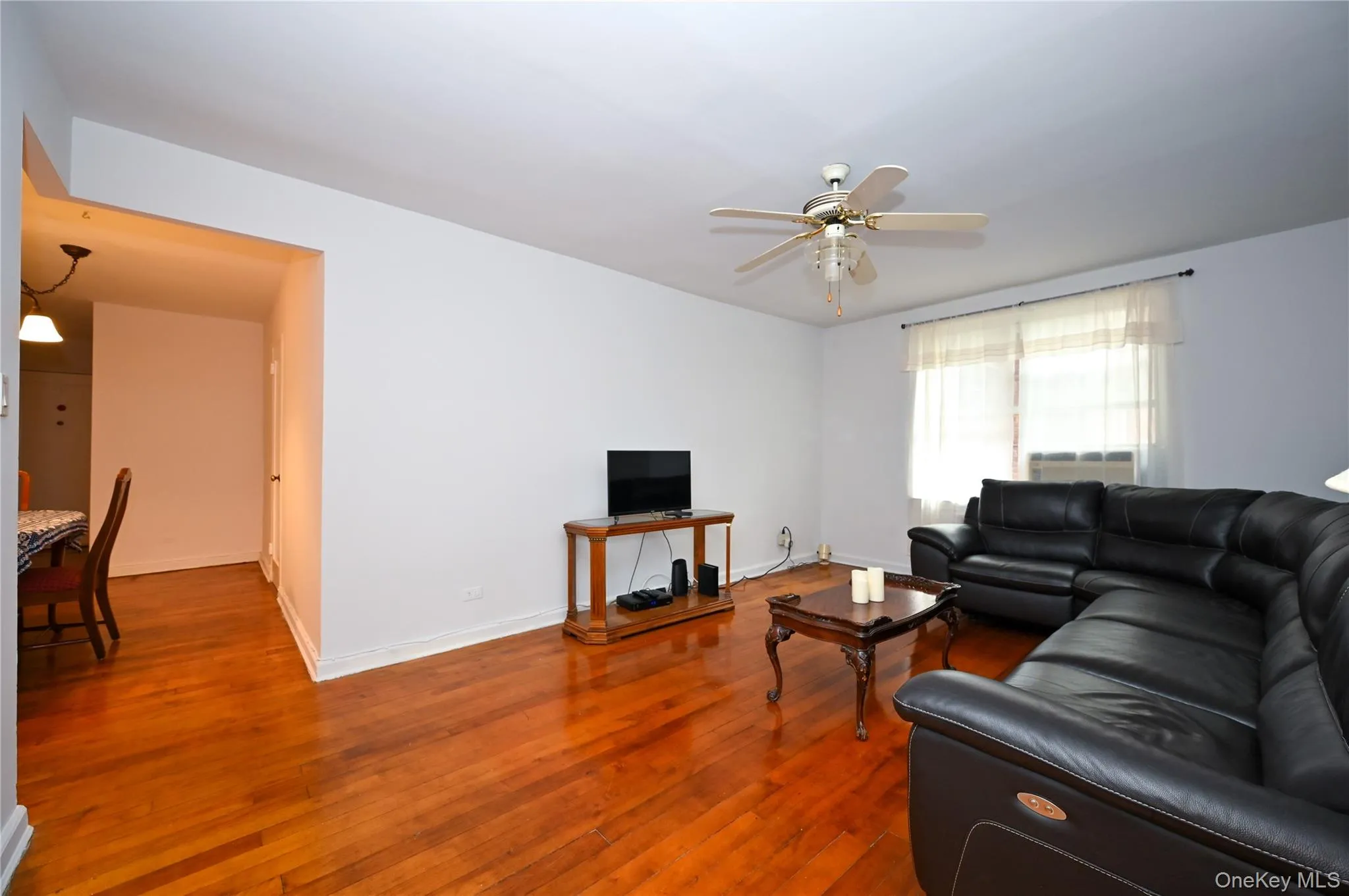 Living room featuring wood-type flooring and ceiling fan Living room featuring wood-type flooring and ceiling fan