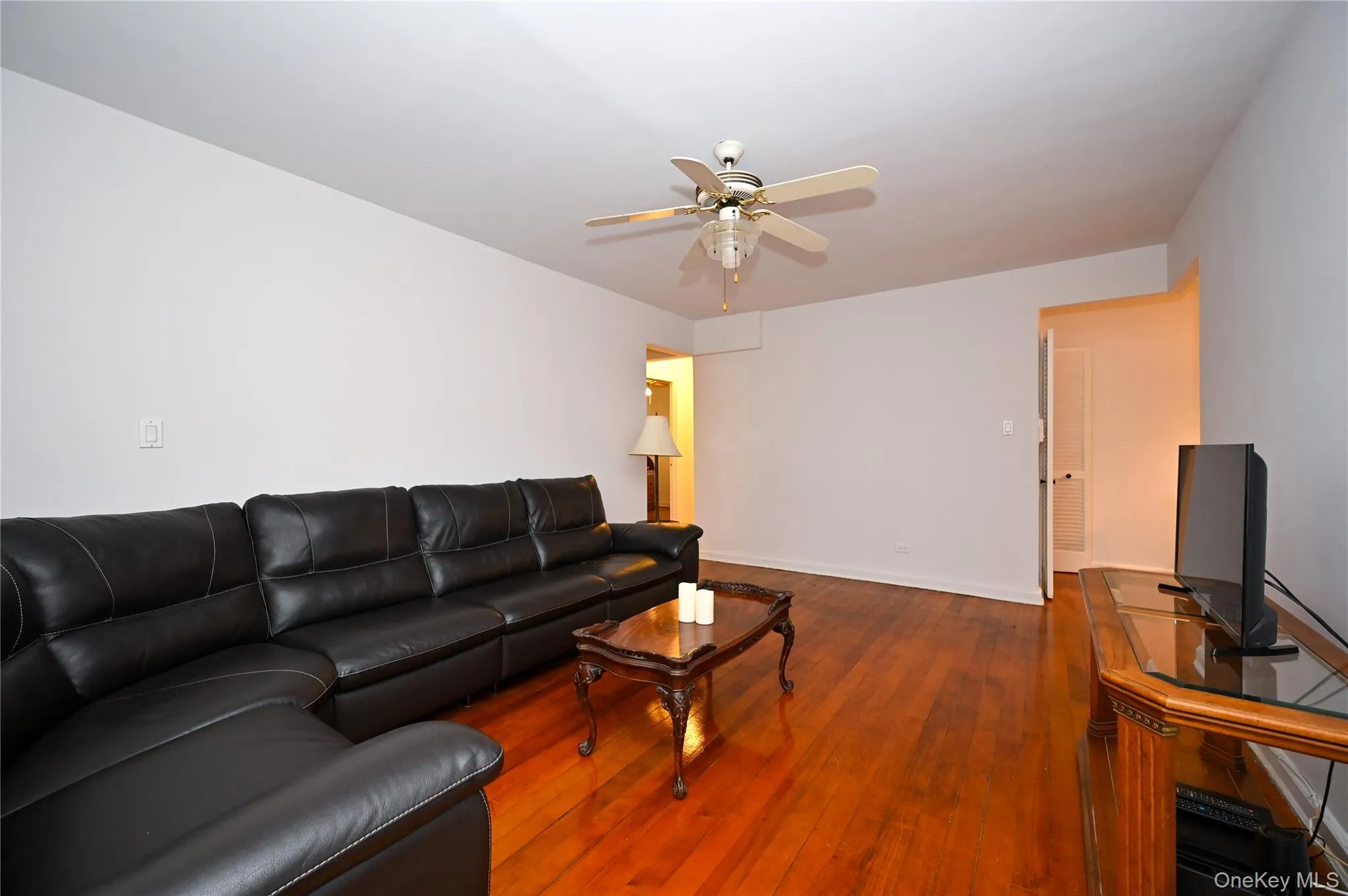 Living room featuring hardwood / wood-style floors and ceiling fan Living room featuring hardwood / wood-style floors and ceiling fan