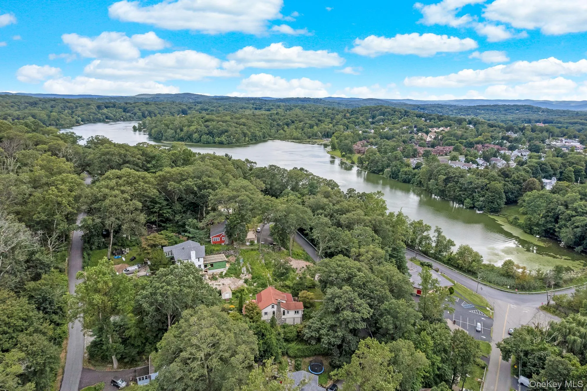 Aerial view of property and surrounding area with a heavily wooded area and a large body of water Aerial view of property and surrounding area with a heavily wooded area and a large body of water